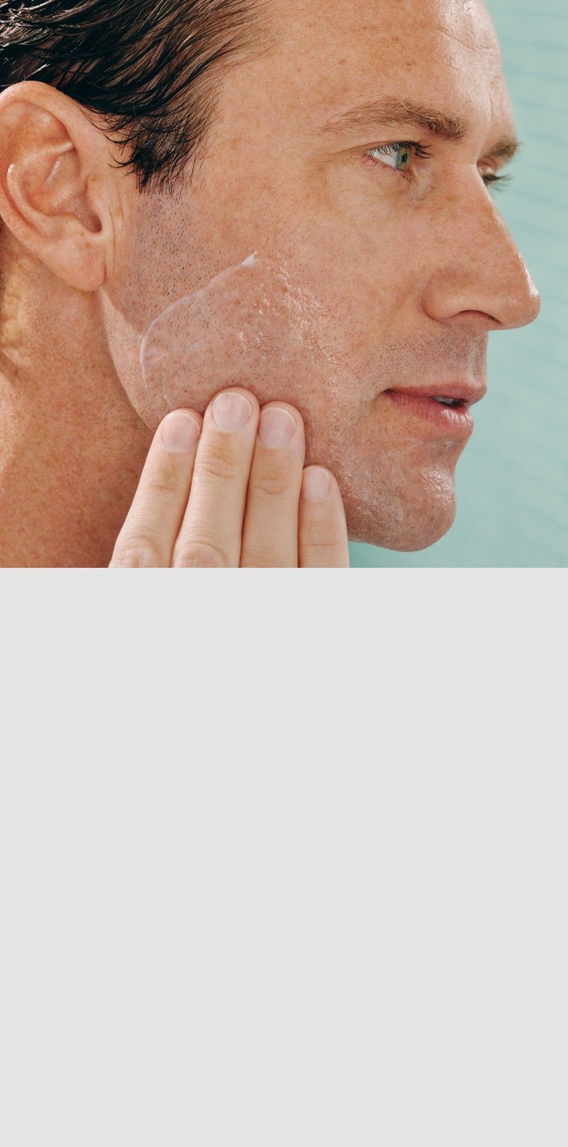 Man applying lotion to his cheek