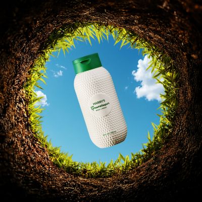 bottle of Greenskeeper Body Wash about to fall down a golf hole, looking up through the hole