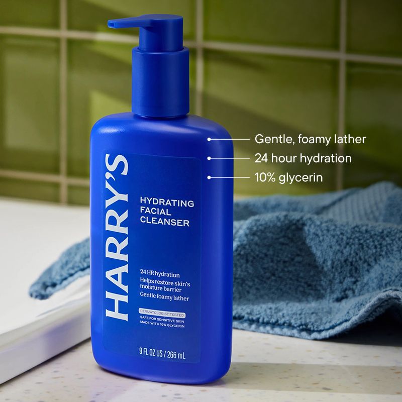 Hydrating Facial Cleanser blue bottle, by a sink, on a counter, next to a hand towel, with product details pointing to bottle