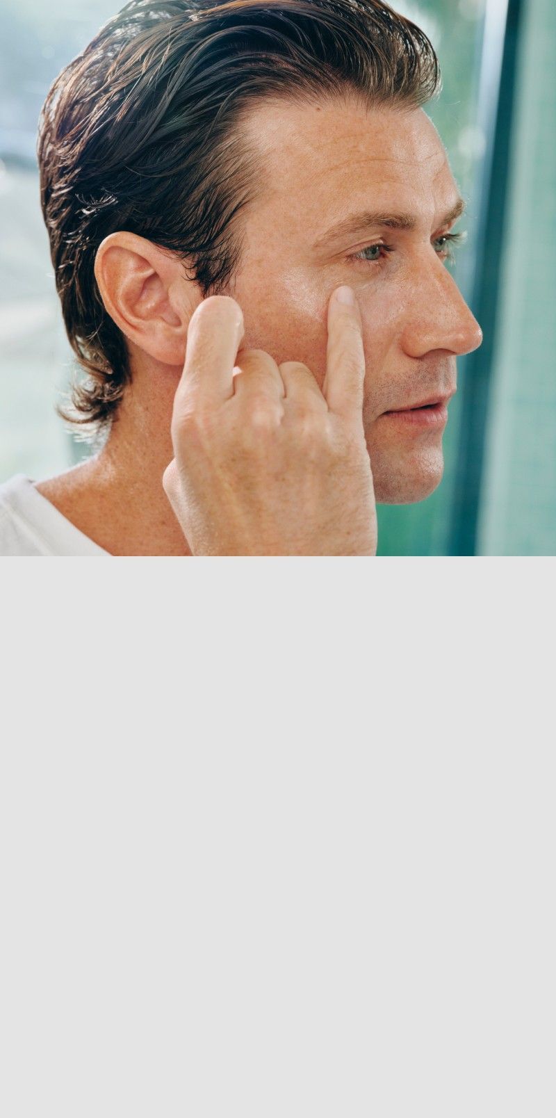 Man applying product to the under-eye area using his pinky