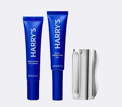 Blue bottles of face care products that have white next on them against a grey background