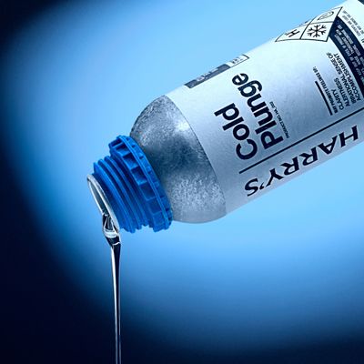 Bottle pouring out Cold Plunge Body Wash against blue background