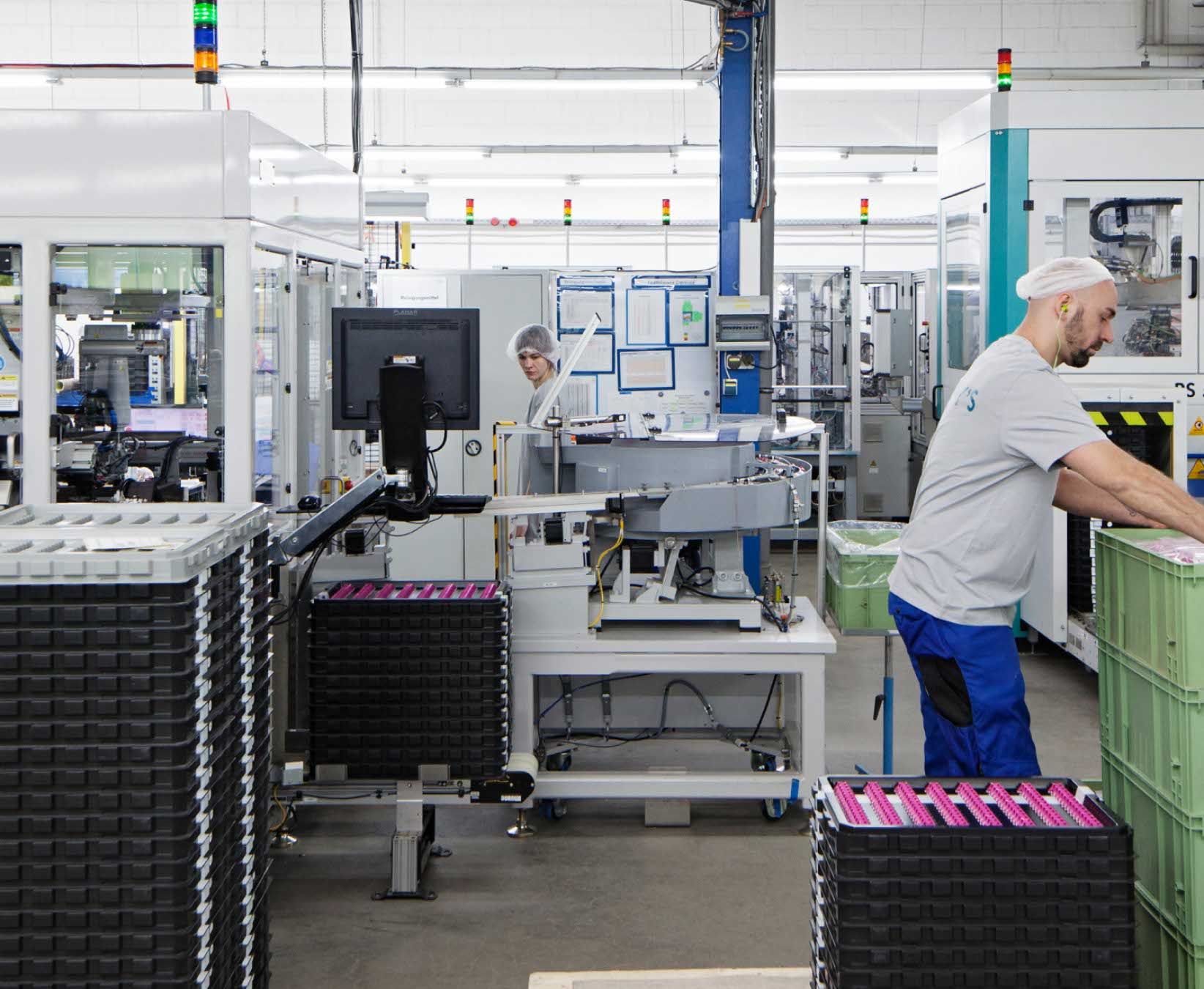 Two people among factory equipment at Harry's factory.