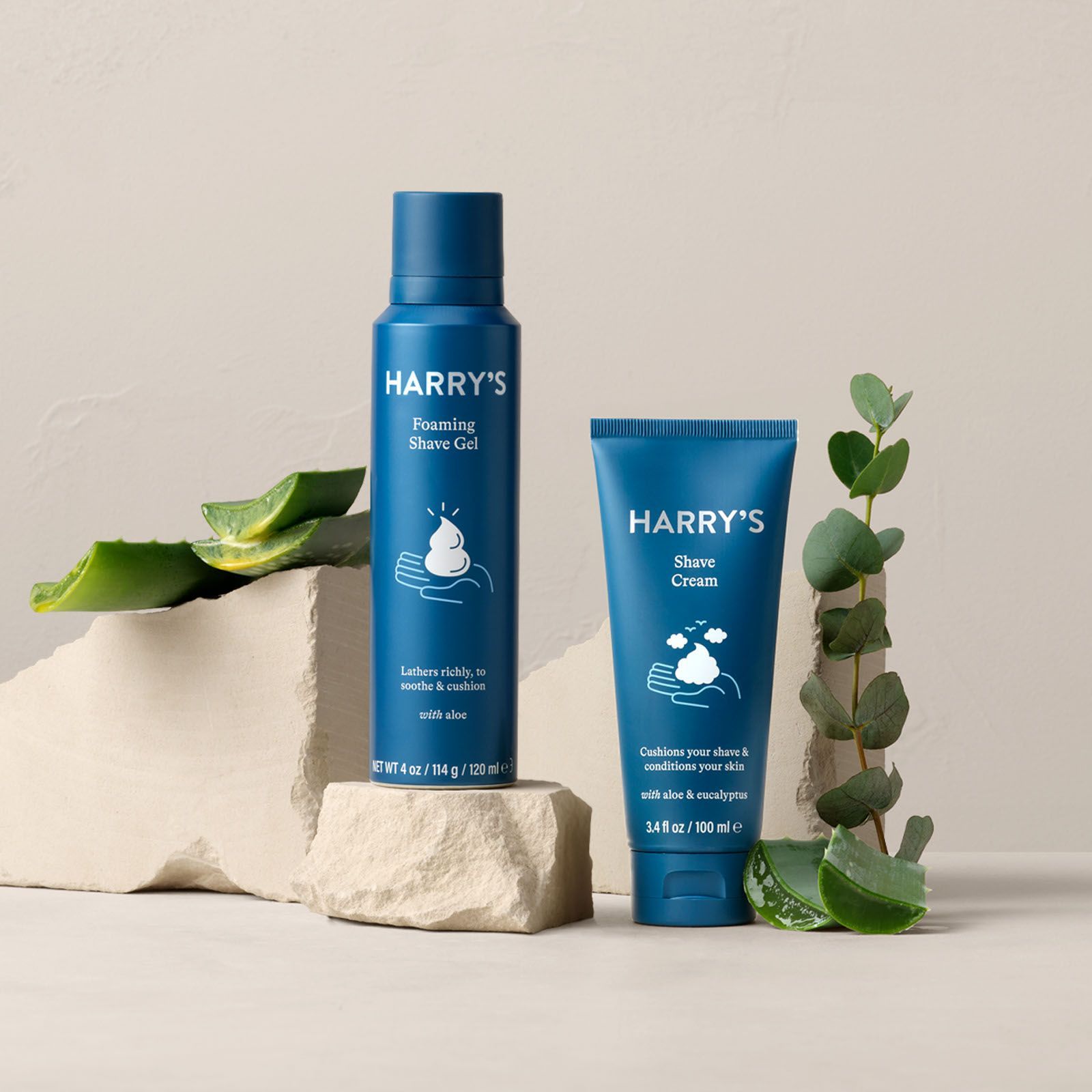 Shave Gel and Shave Cream surrounded by Aloe and Eucalyptus leaves.