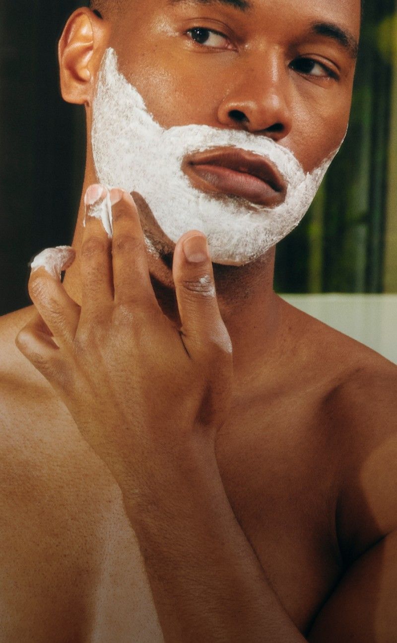 Man applying shaving cream to his face.