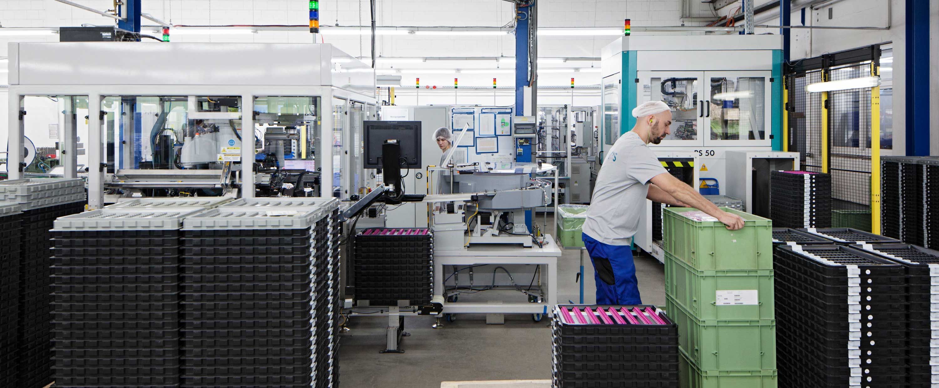 Two people among factory equipment at Harry's factory.