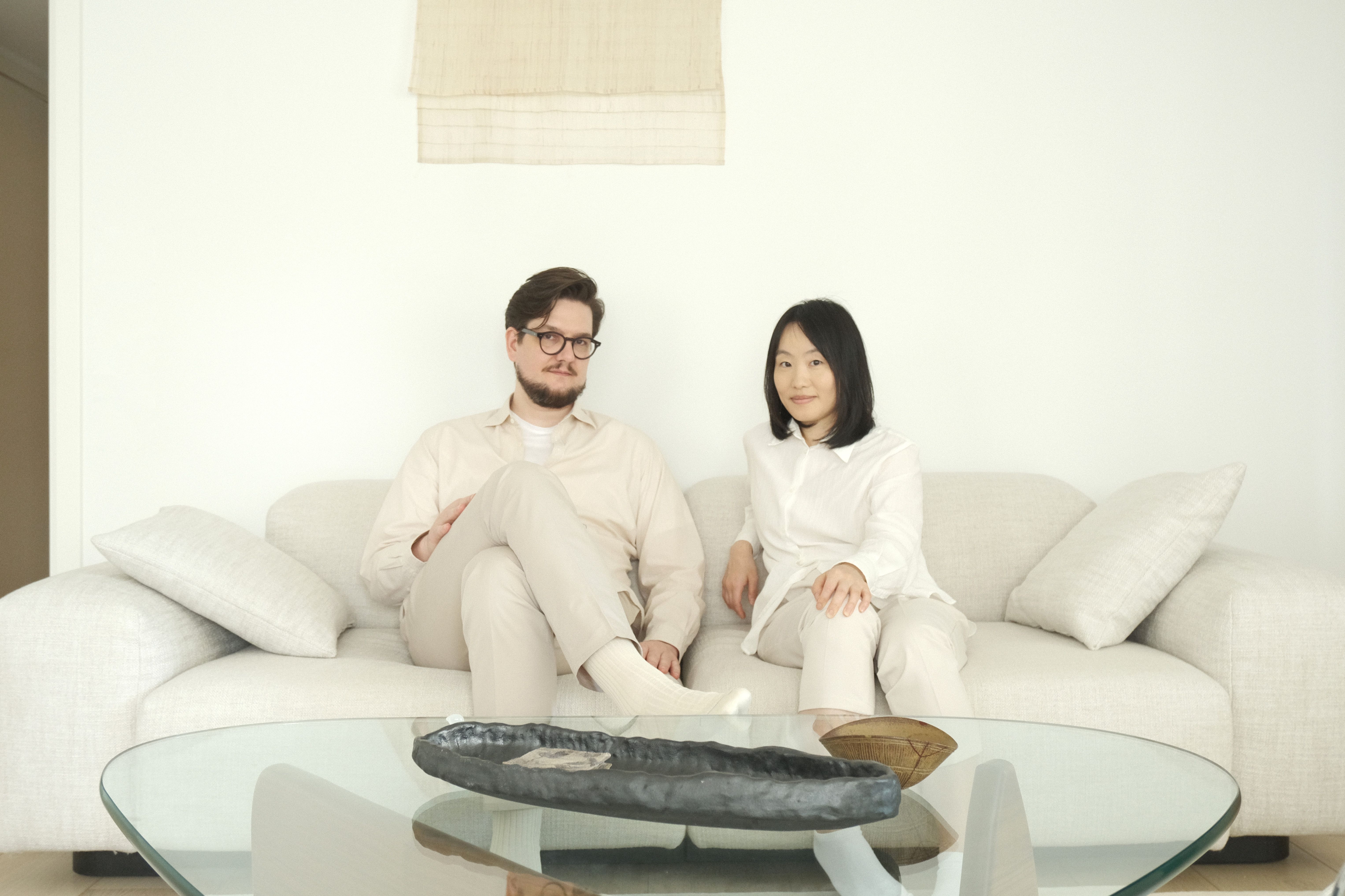 Picture of Mimi and Markus sitting in a couch, looking into the camera.