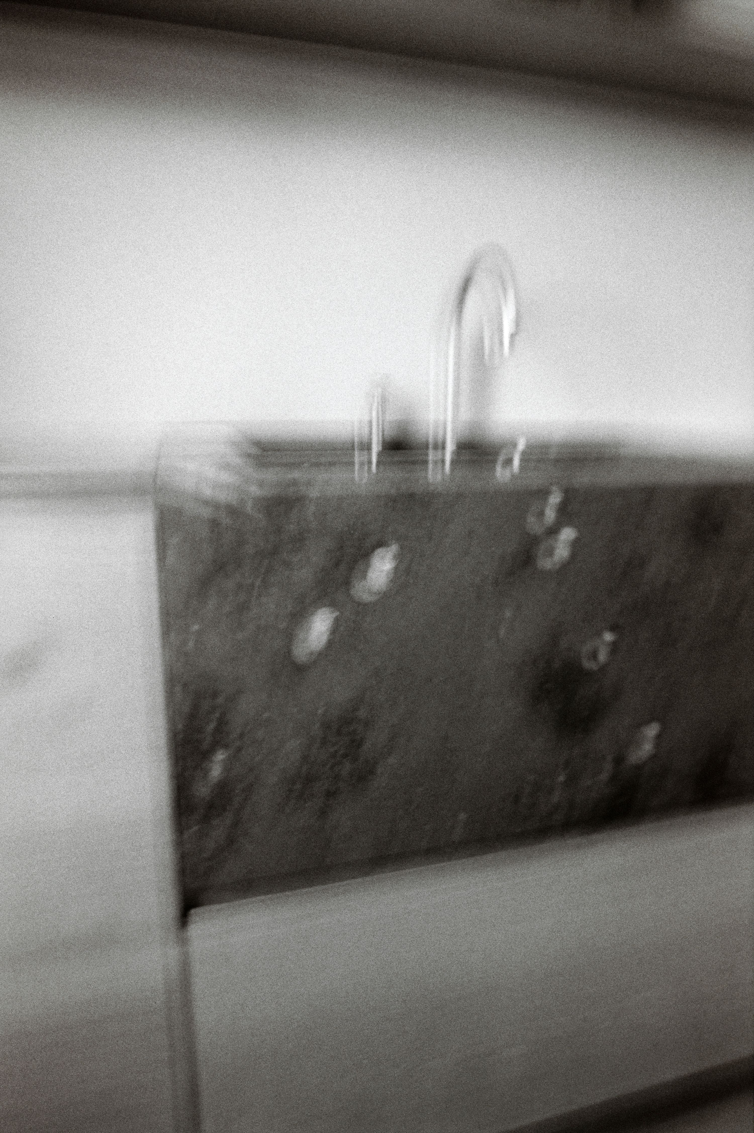 a blurry black and white image of a kitchen sink and faucet