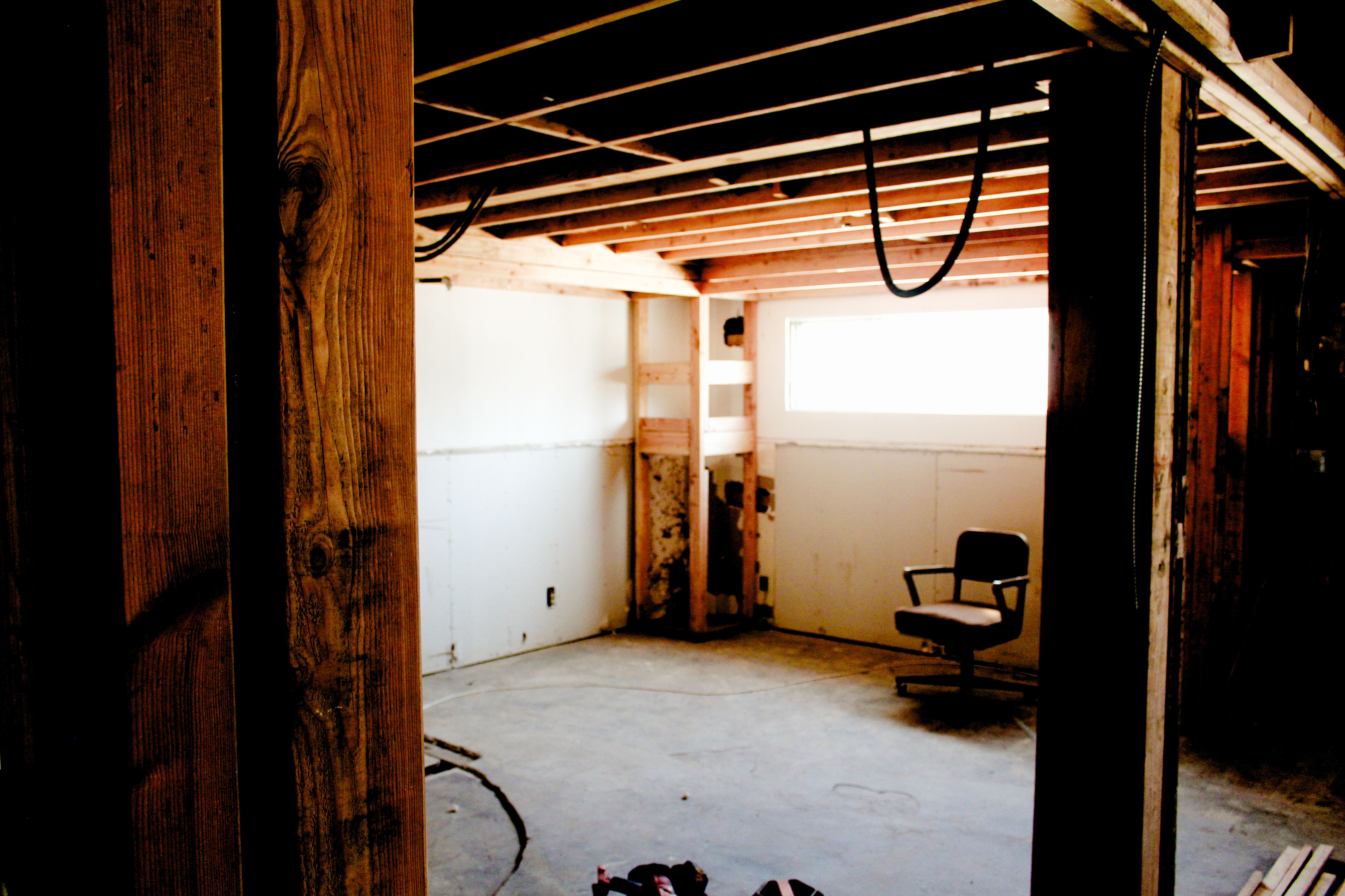 a construction site with a bright window and a chair underneath, WOE, Width Over Ears
