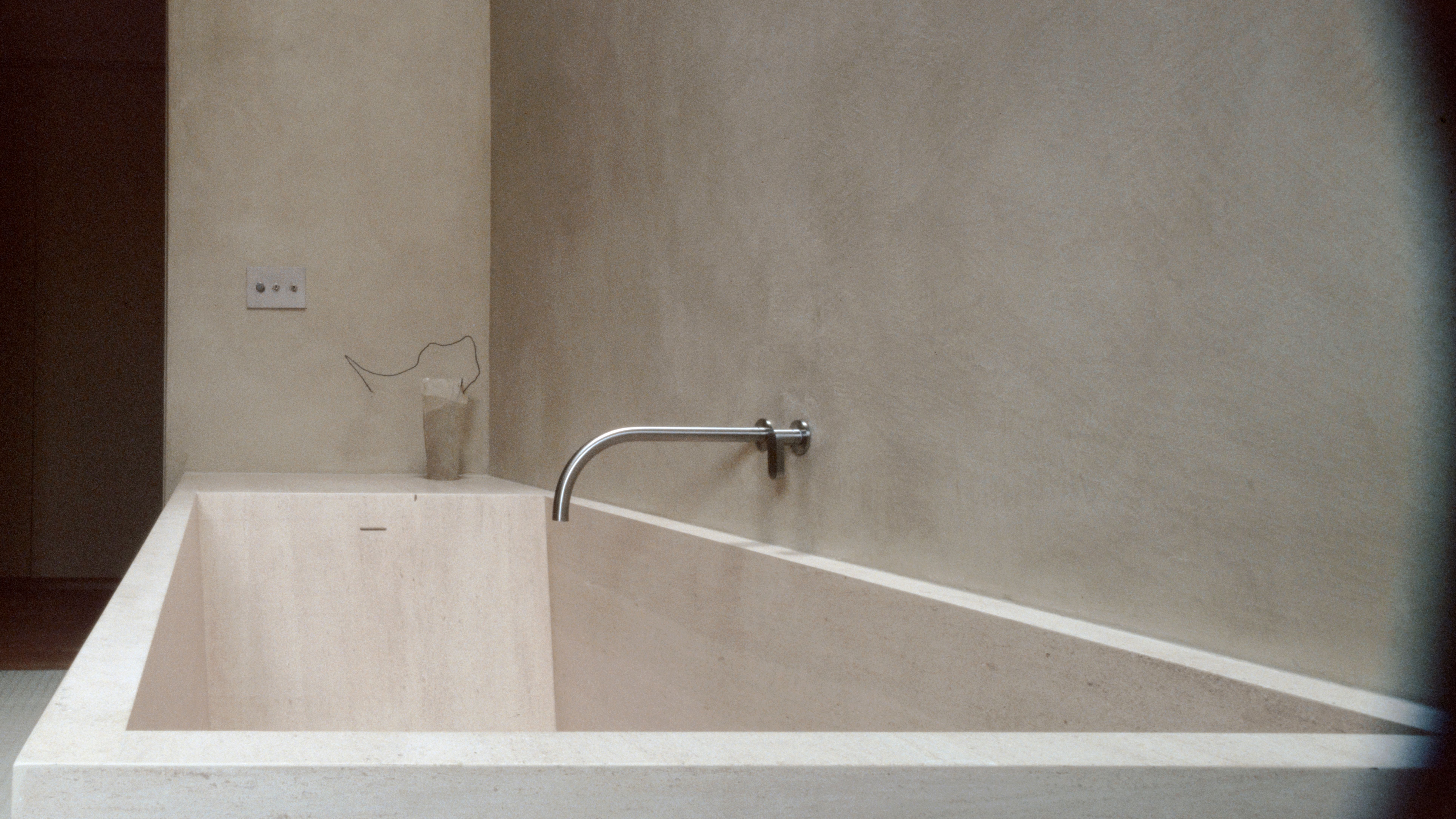 a stone bath tub with silver plumbing and textured wall, WOE, Width Over Ears