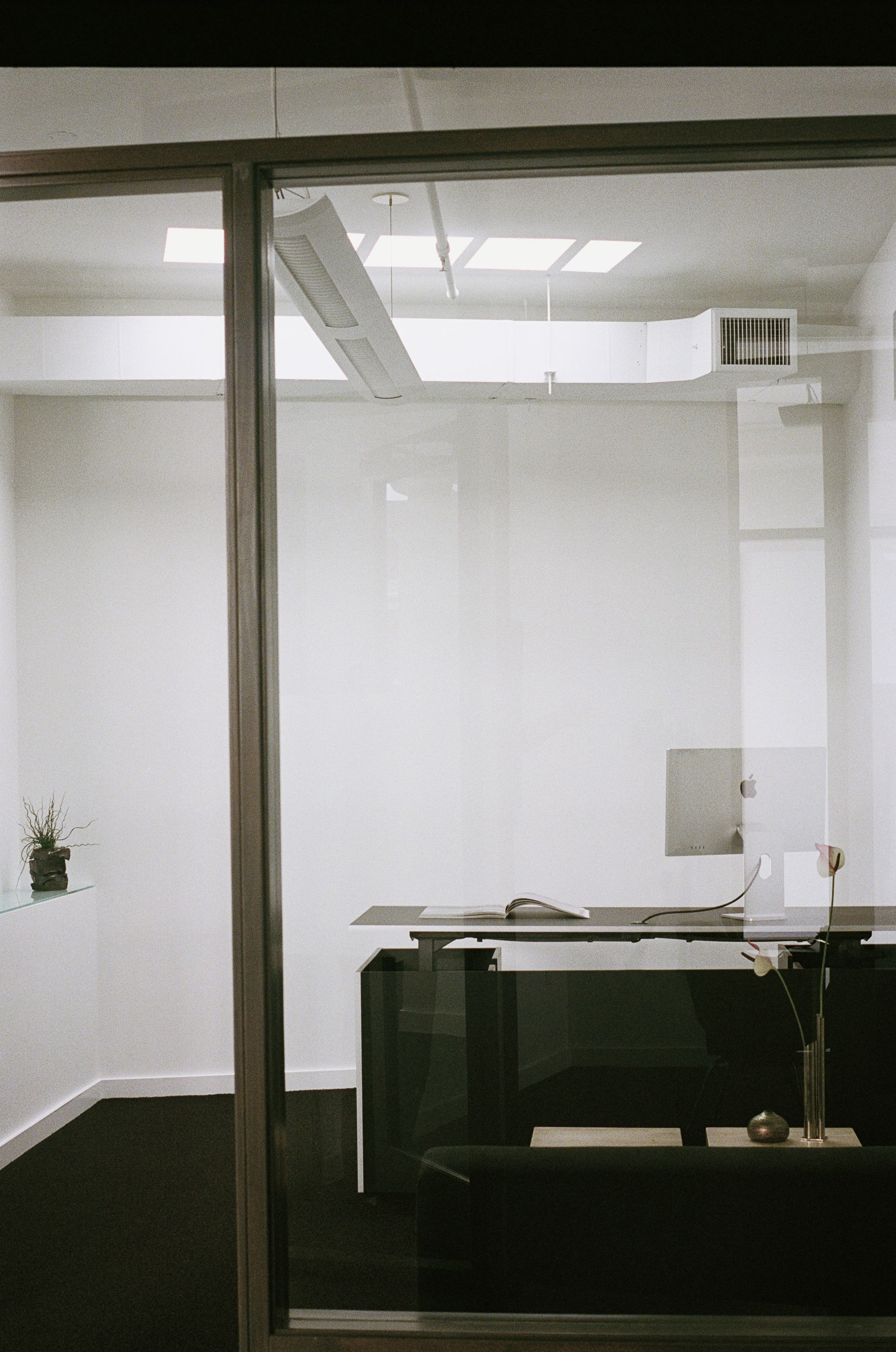 an office with adjustable work desk and a skylight above