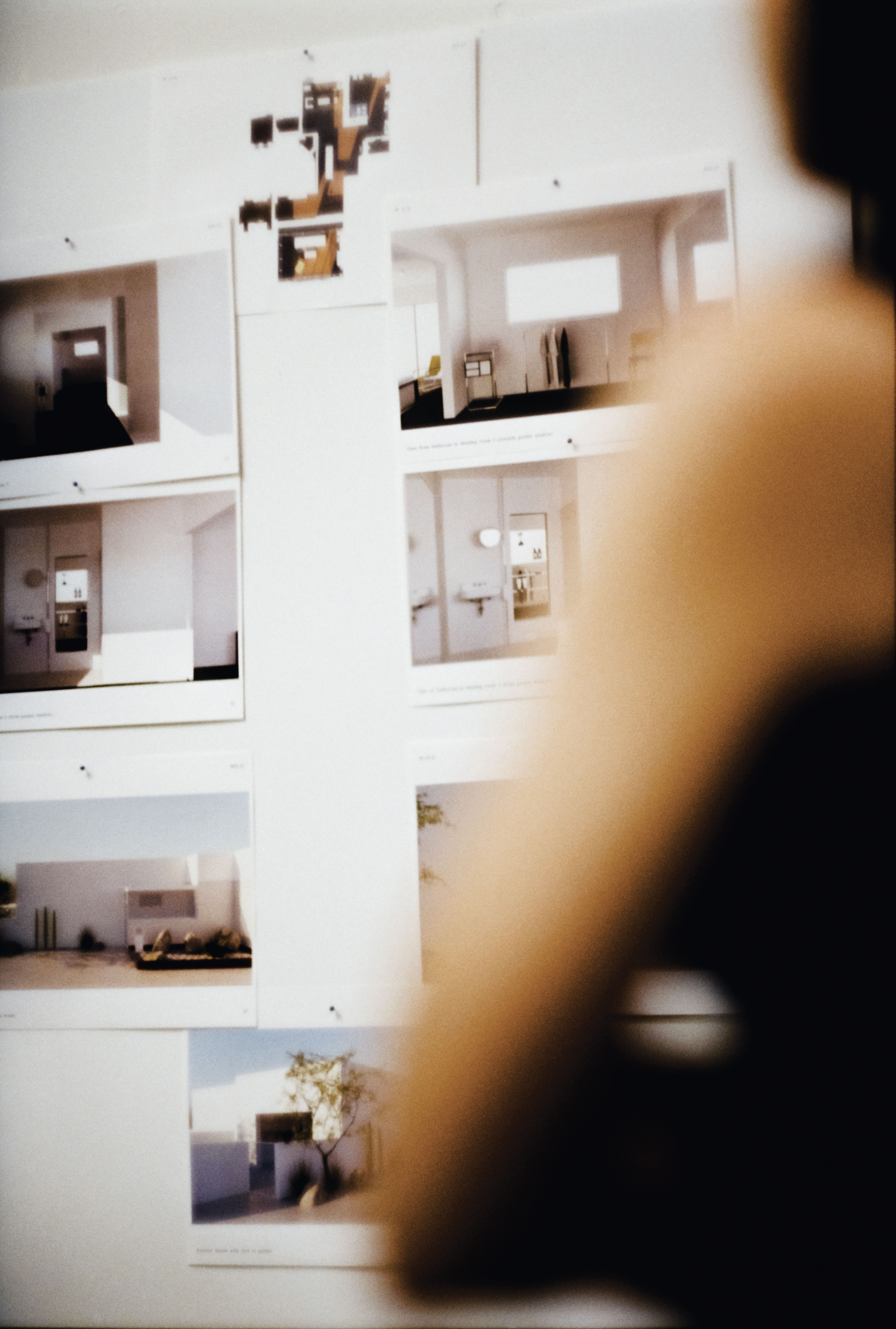 images pinned to a white wall with a persons arm in the foreground, WOE, Width Over Ears