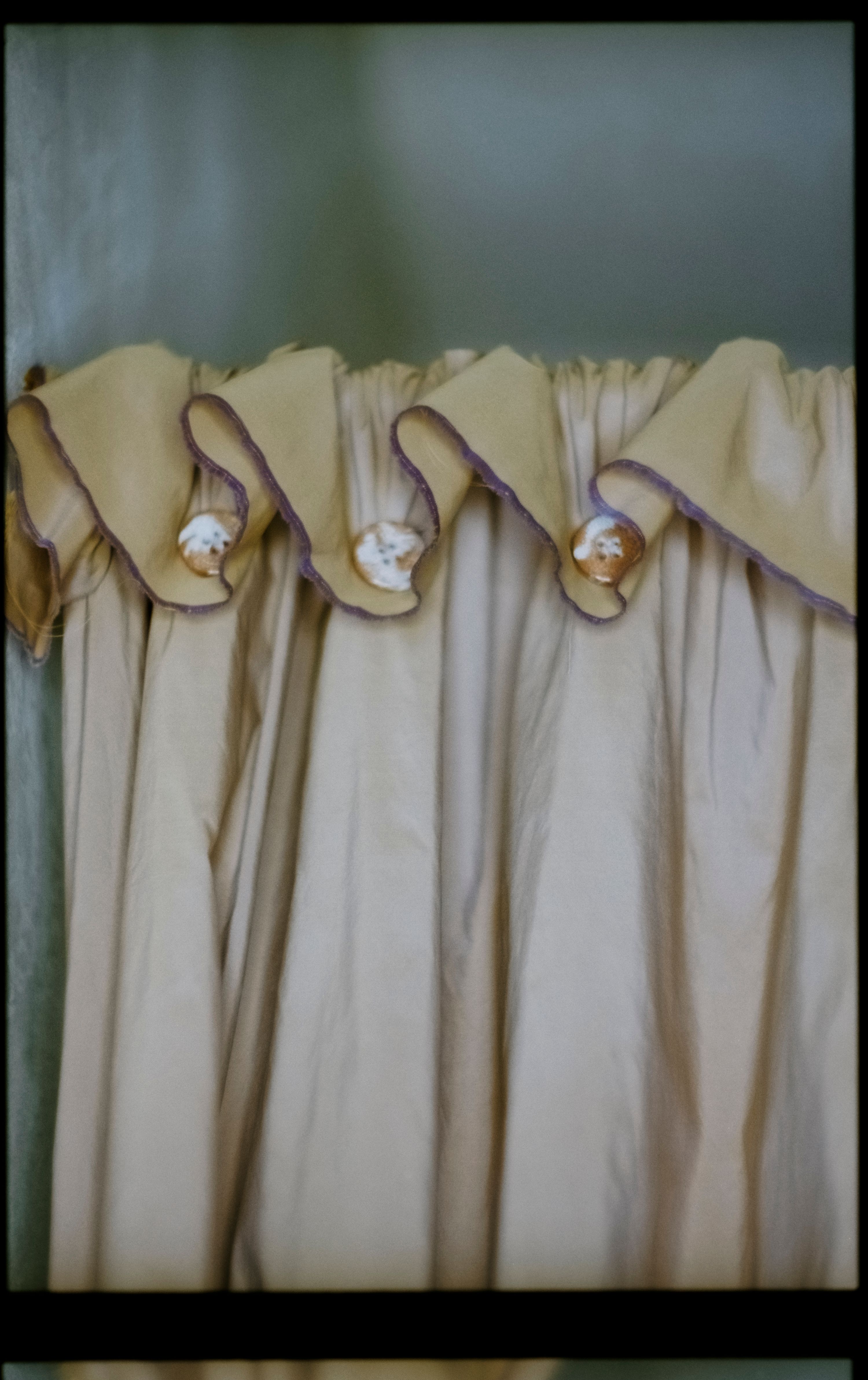 a gathered orange silk curtain with ceramic buttons, WOE, Width Over Ears