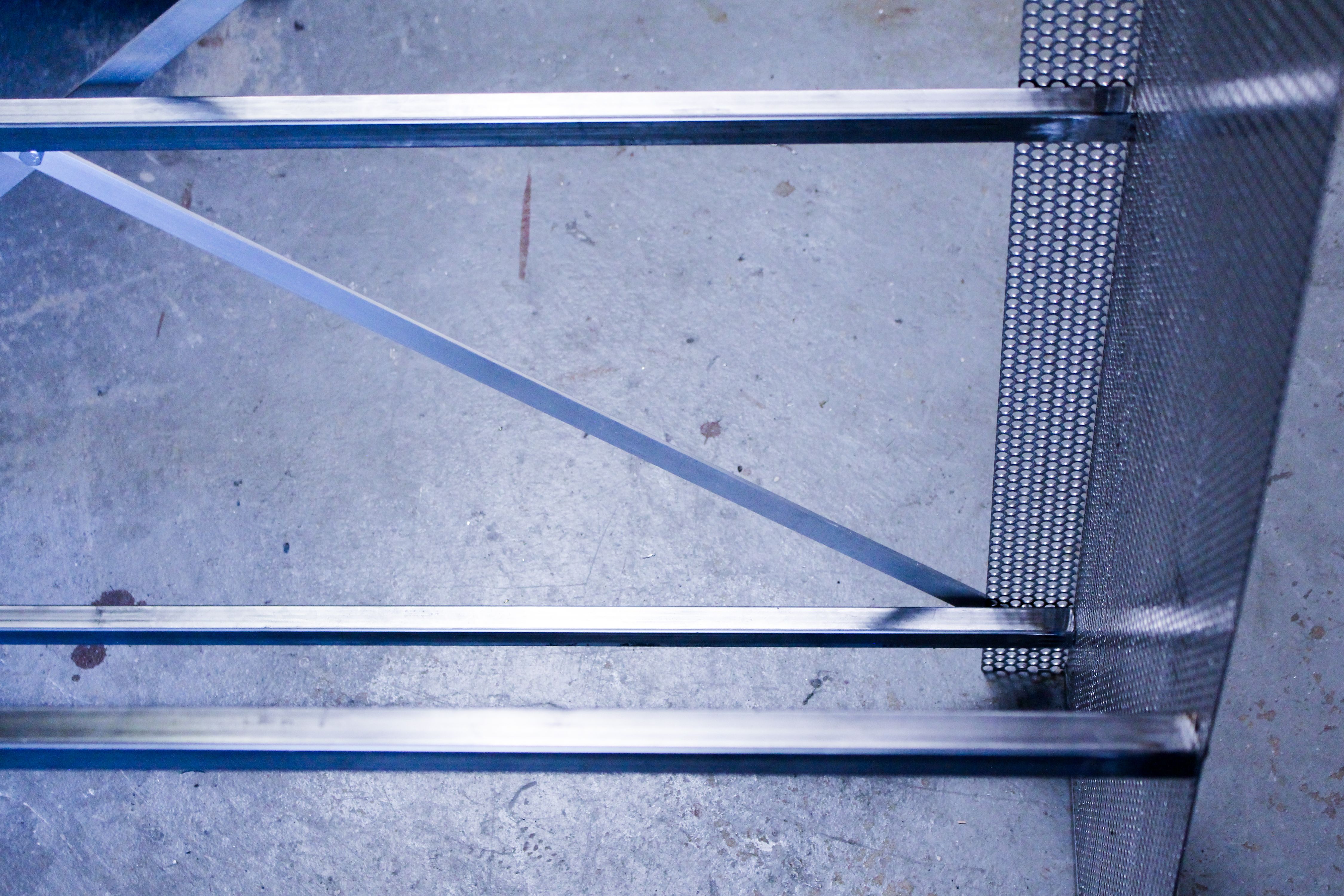 a detail of a bookshelf framework in perforated and tubular steel, WOE, Width Over Ears