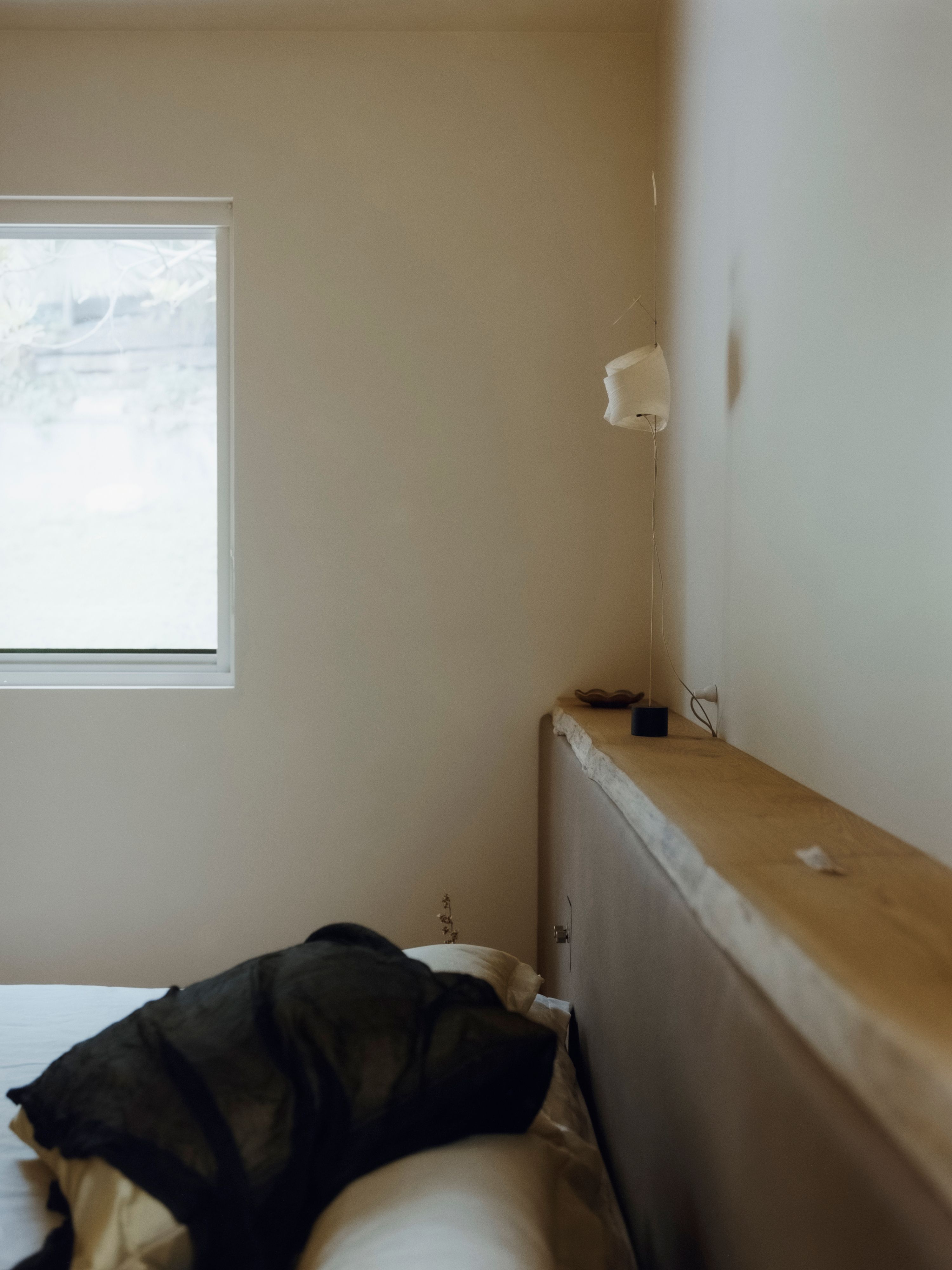 a bedroom with long wooden headboard and a large side window, WOE, Width Over Ears