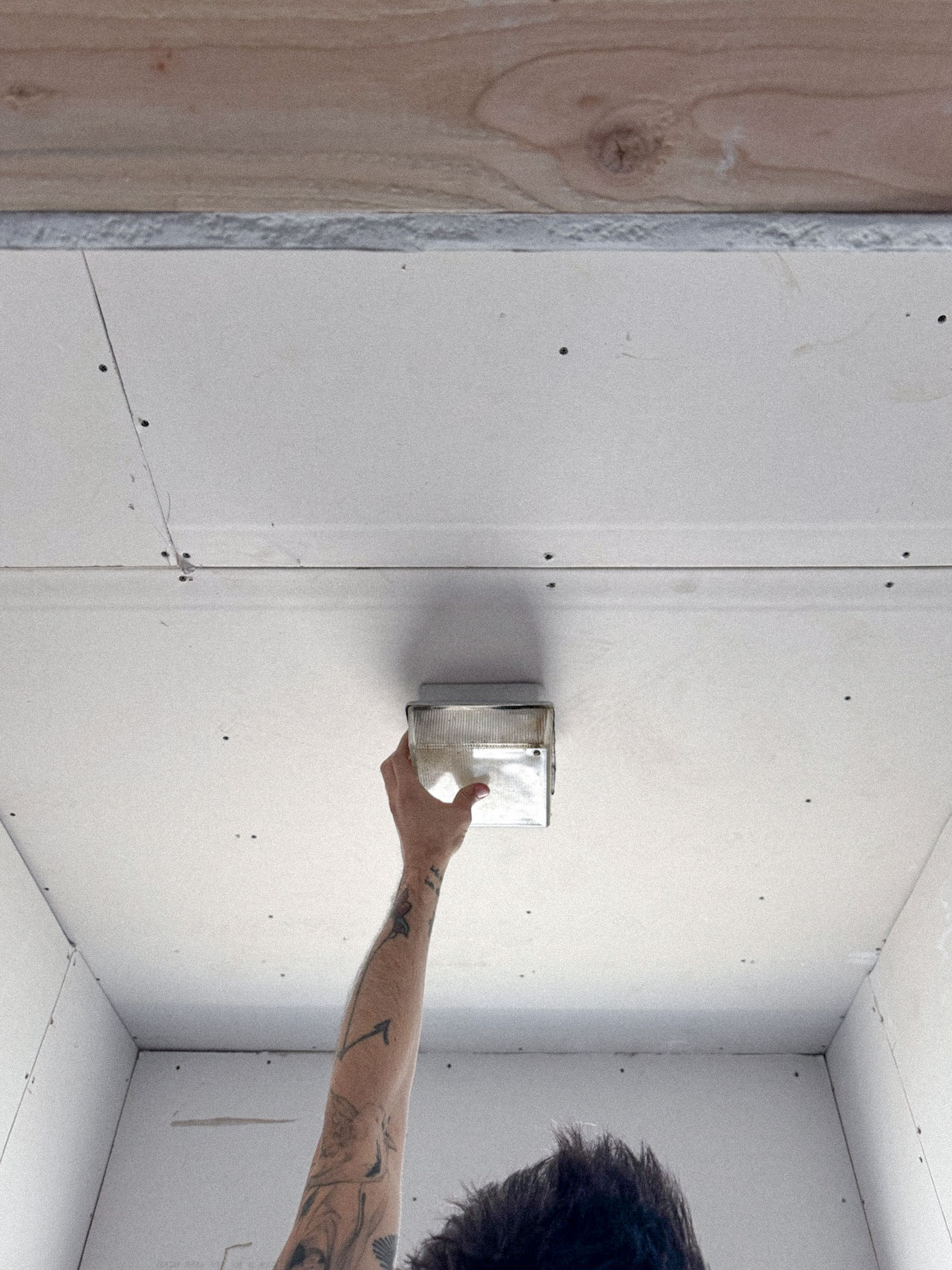 a man holding an industrial light up to the ceiling, WOE, Width Over Ears