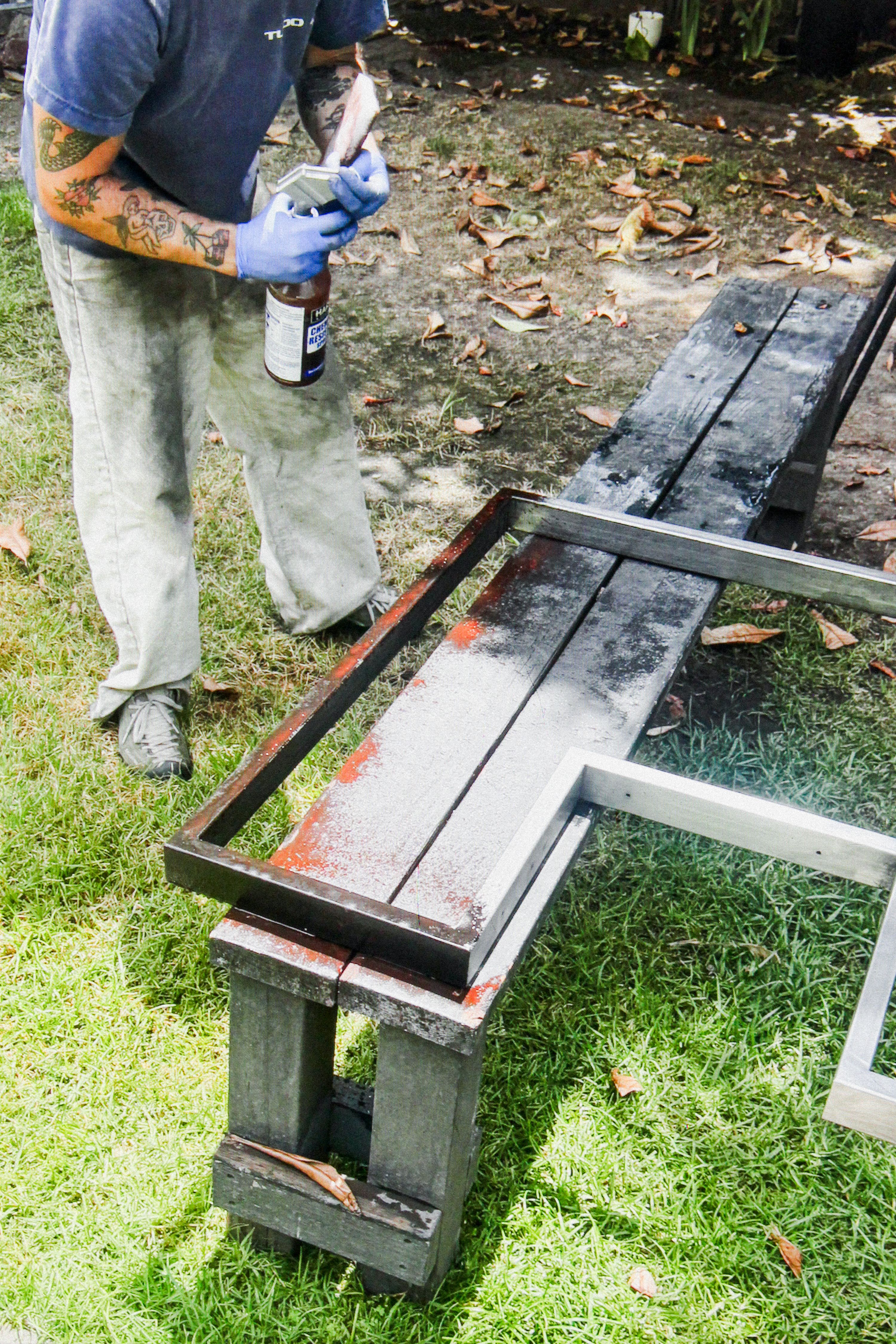 a metal frame resting on wooden benches outside on grass, WOE, Width Over Ears