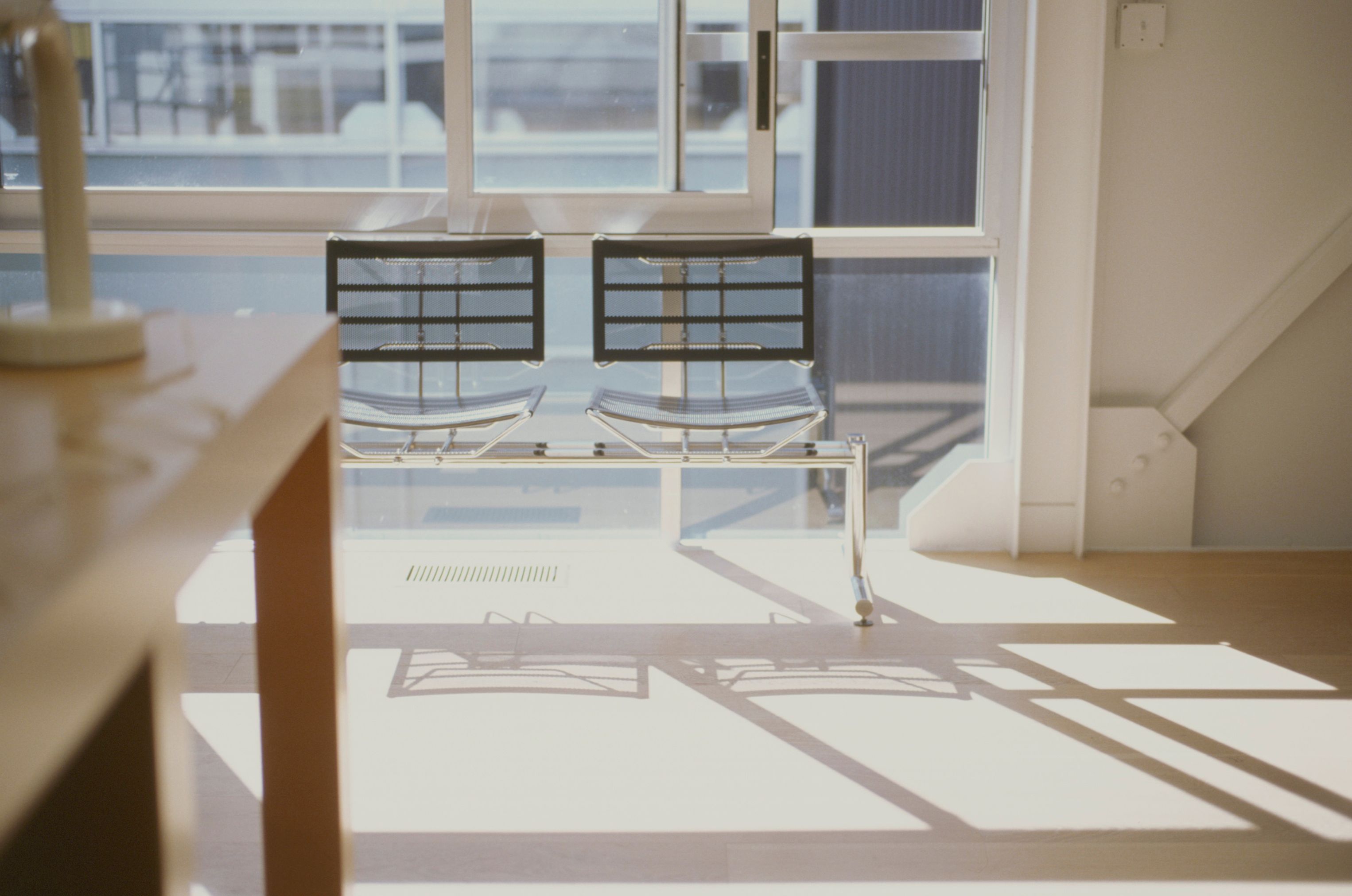 a bench in a room with intense shadows on the floor