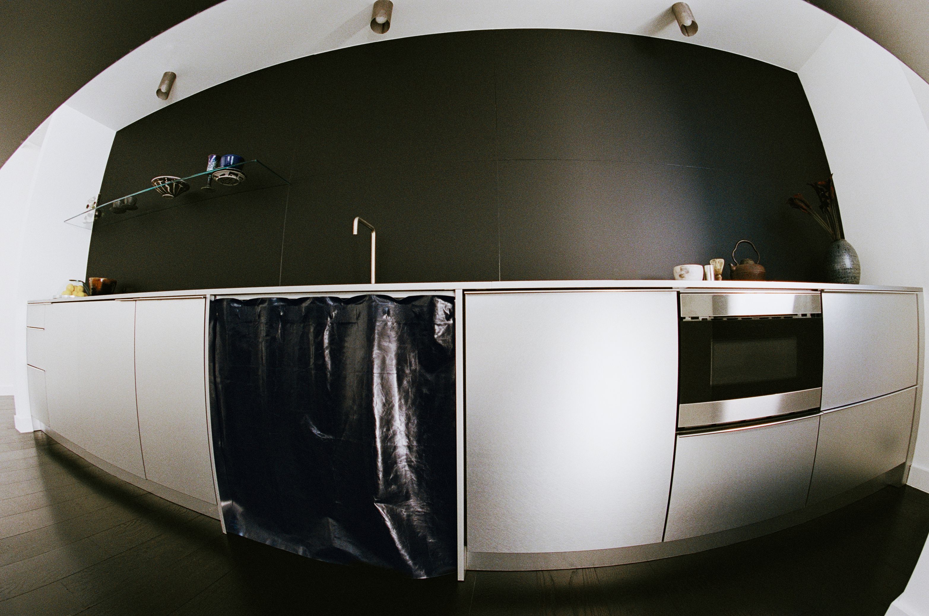 silver kitchen cabinetry with leather sink skirt