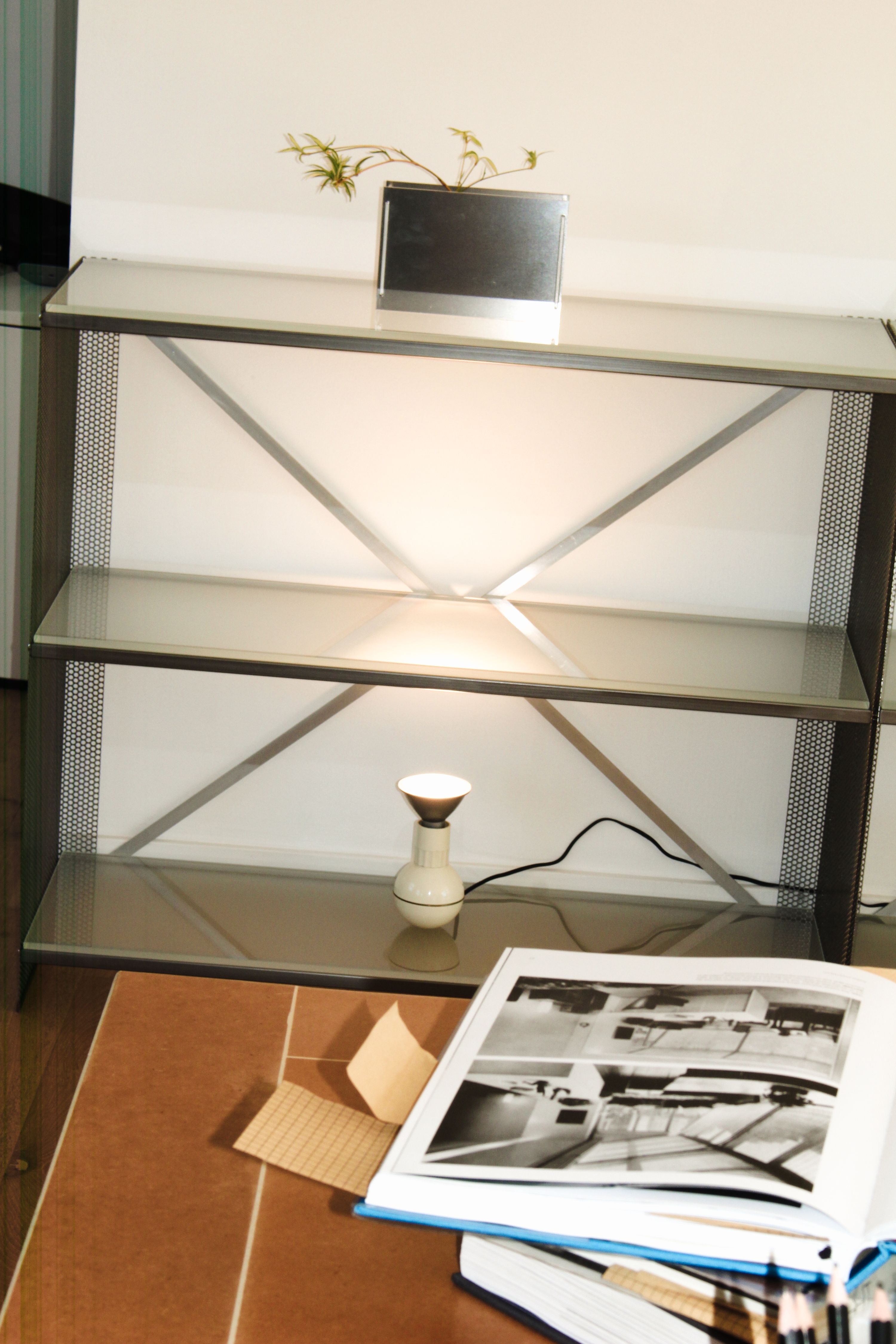 empty bookshelves with a lamp on the bottom shelf shining upwards