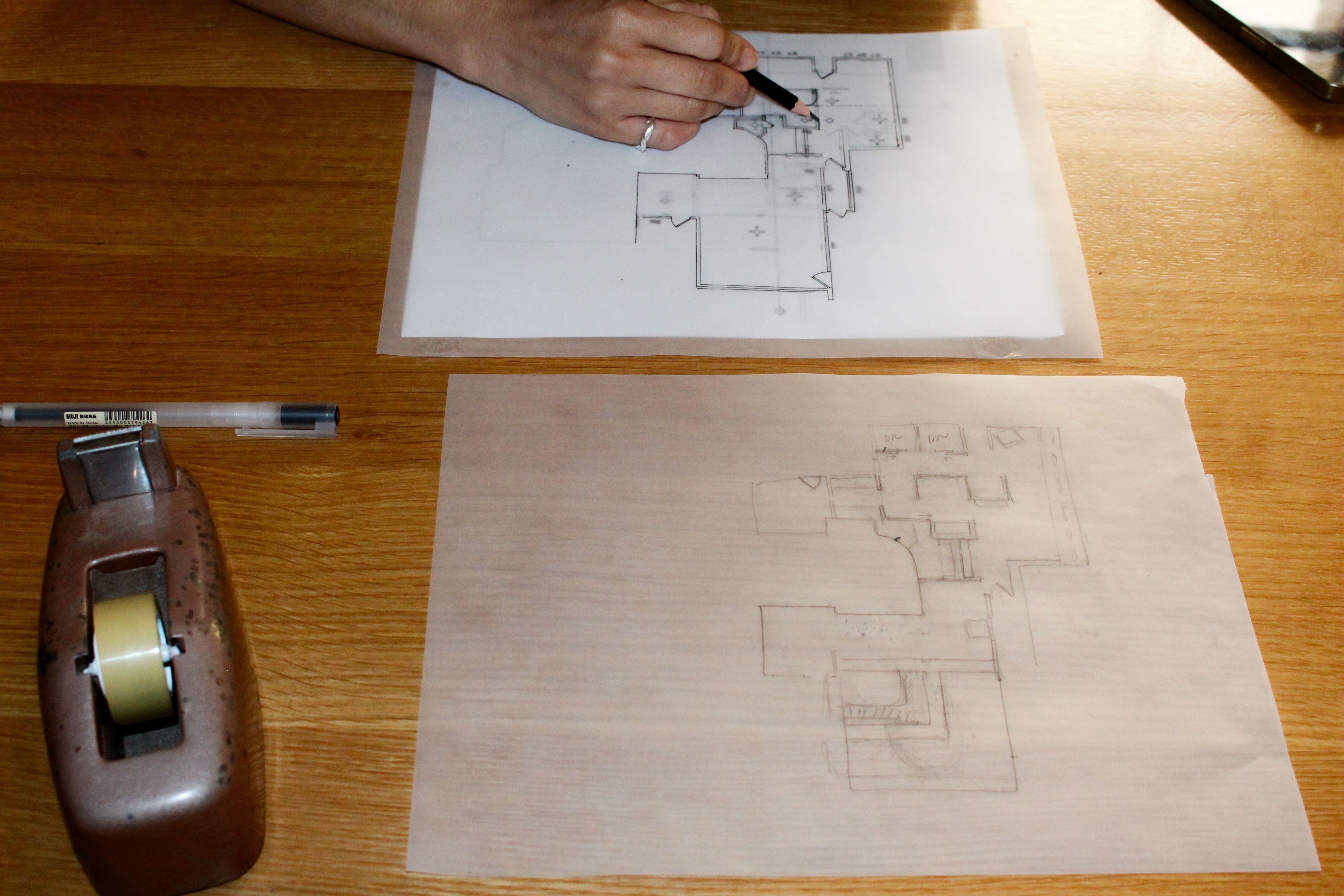 a worktable with floor plans being sketched, WOE, Width Over Ears