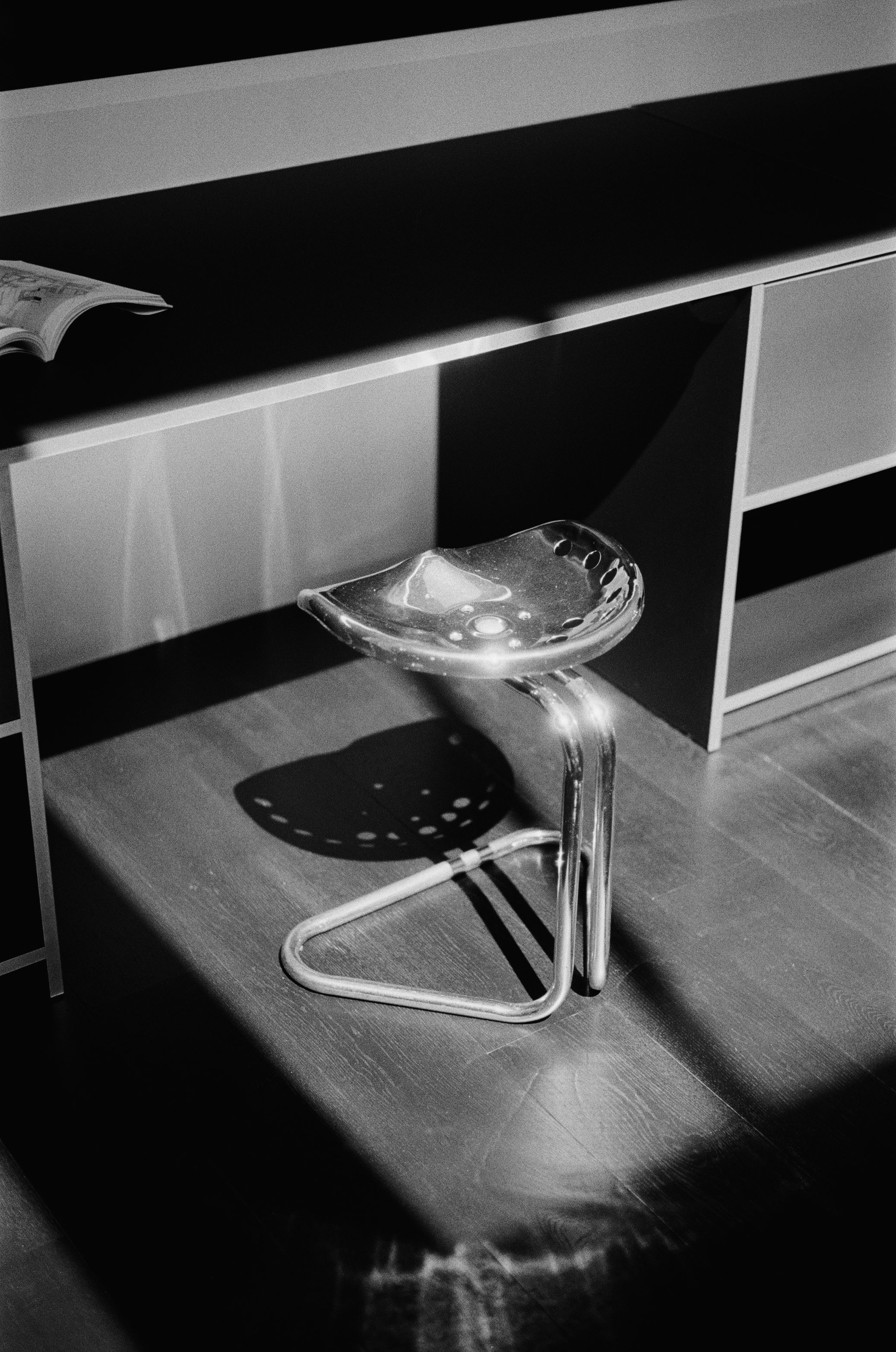 a chrome stool on black wood flooring