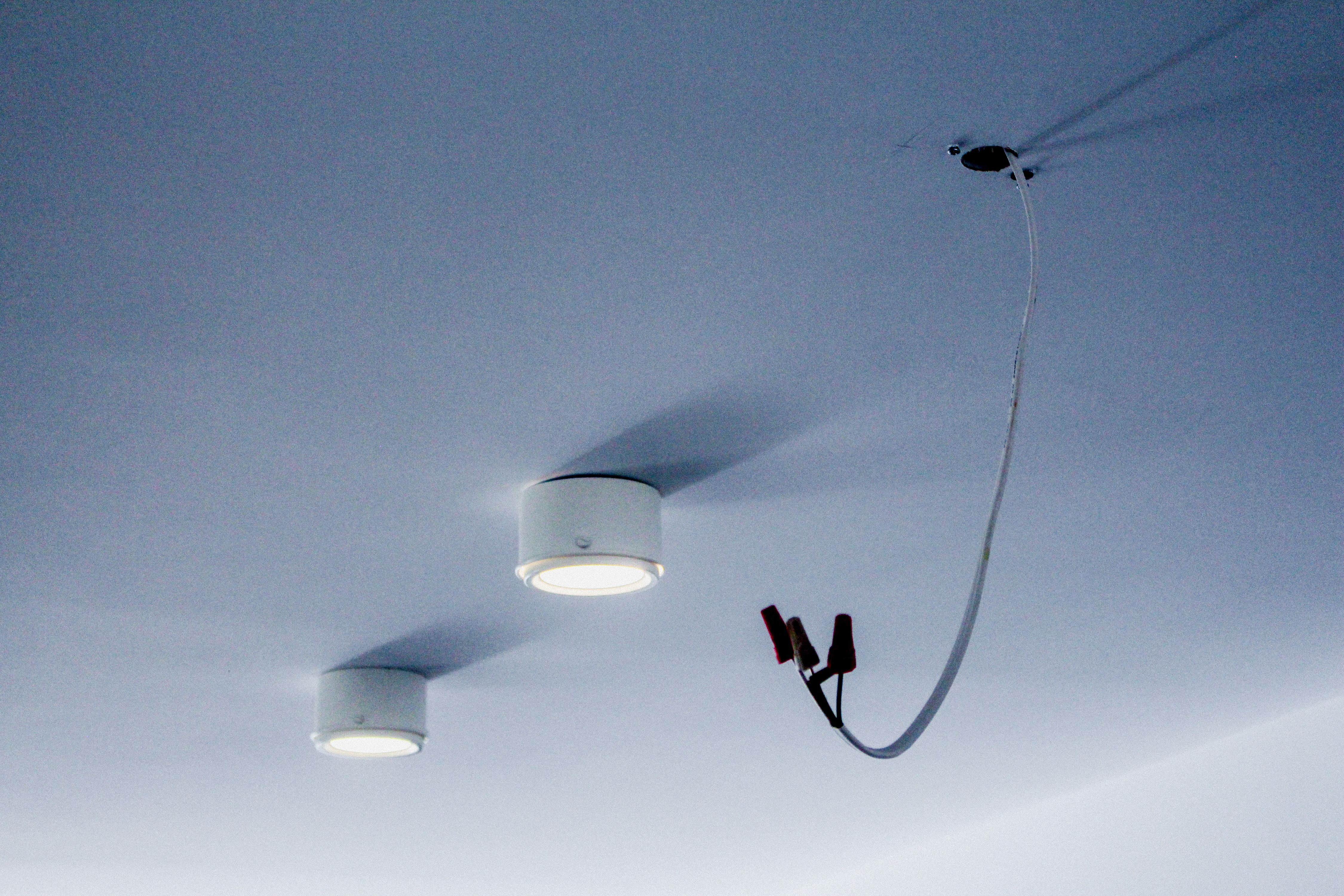 two white ceiling lights and electrical chord coming from ceiling, WOE, Width Over Ears