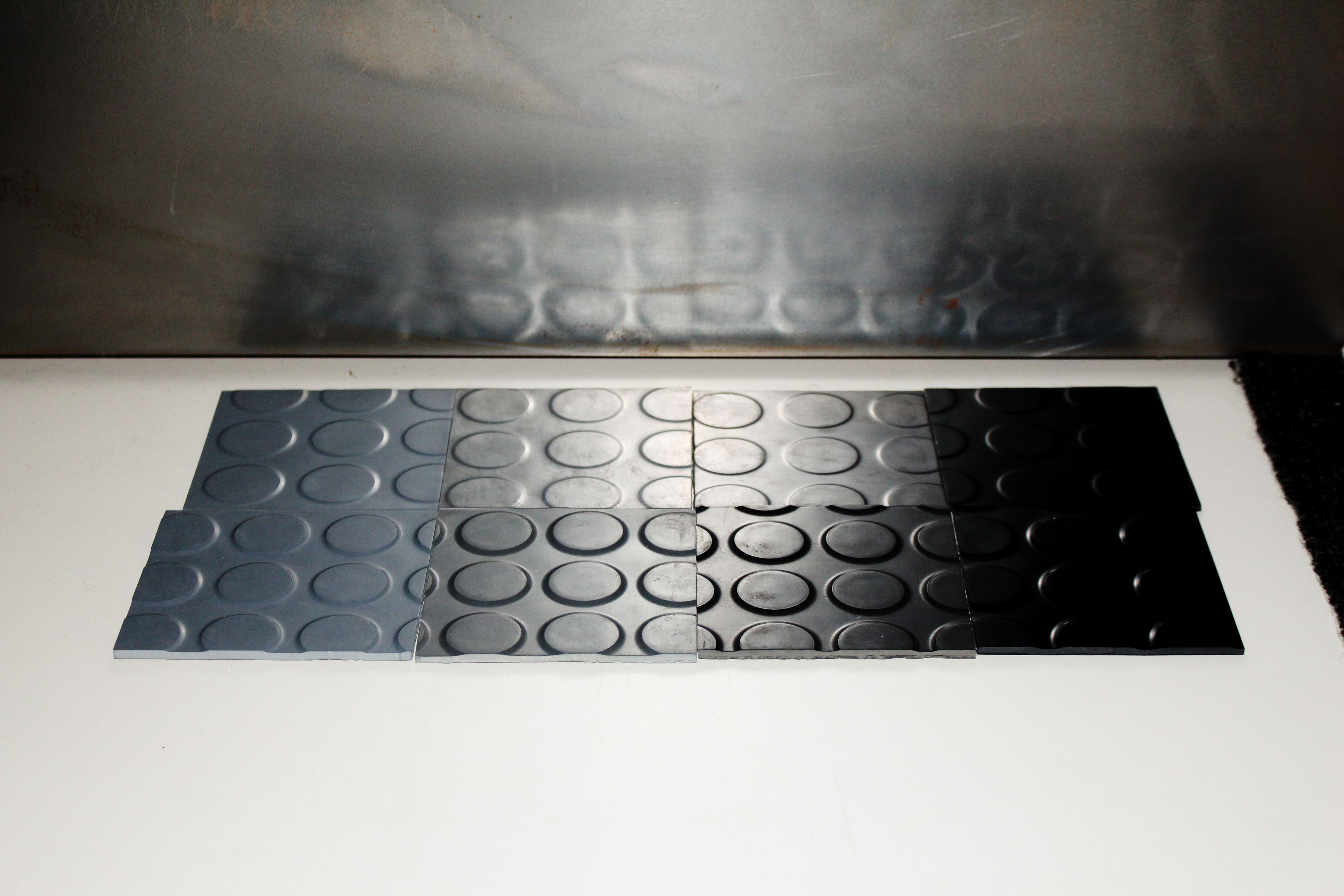 pieces of rubber coin flooring on a white table, WOE, Width Over Ears