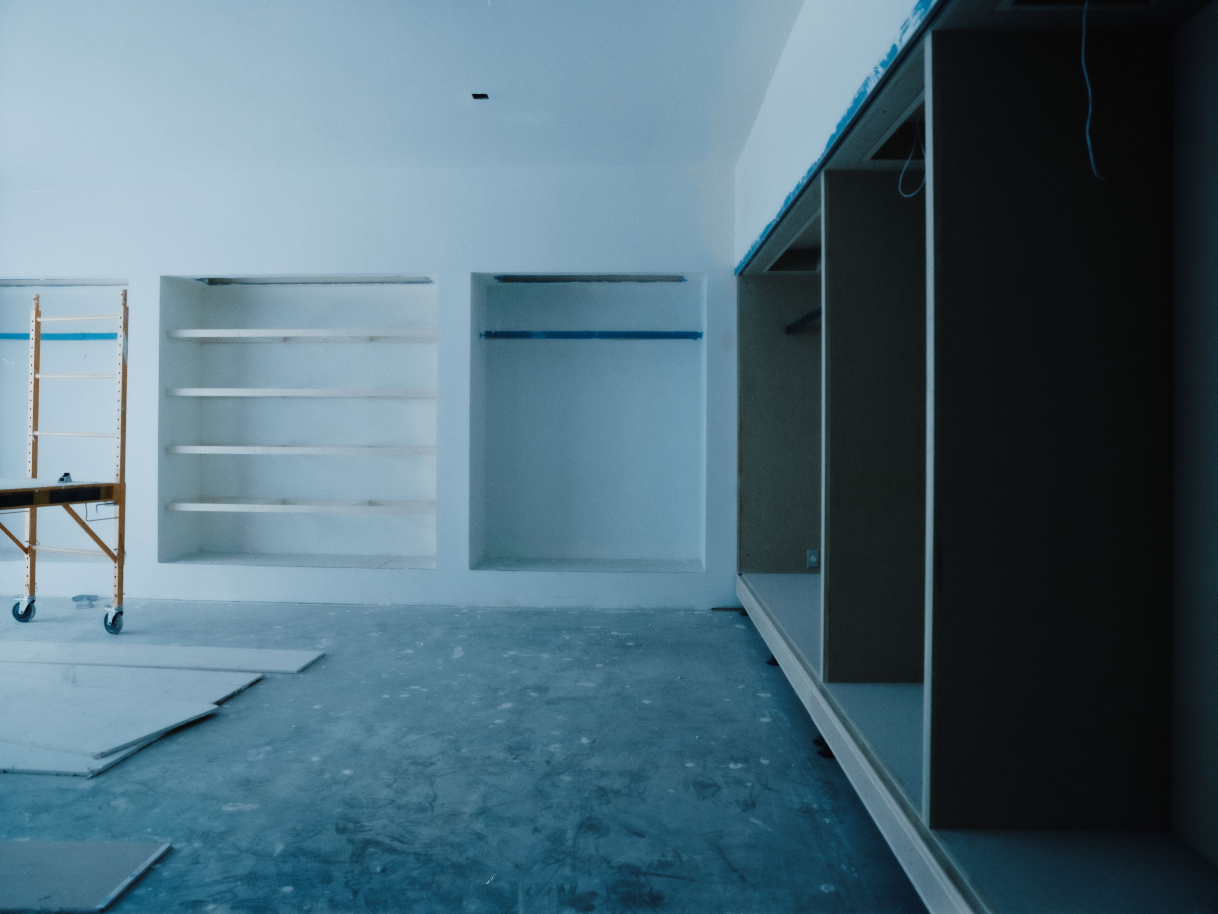 a large room with a blue hue and niches with shelves, WOE, Width Over Ears