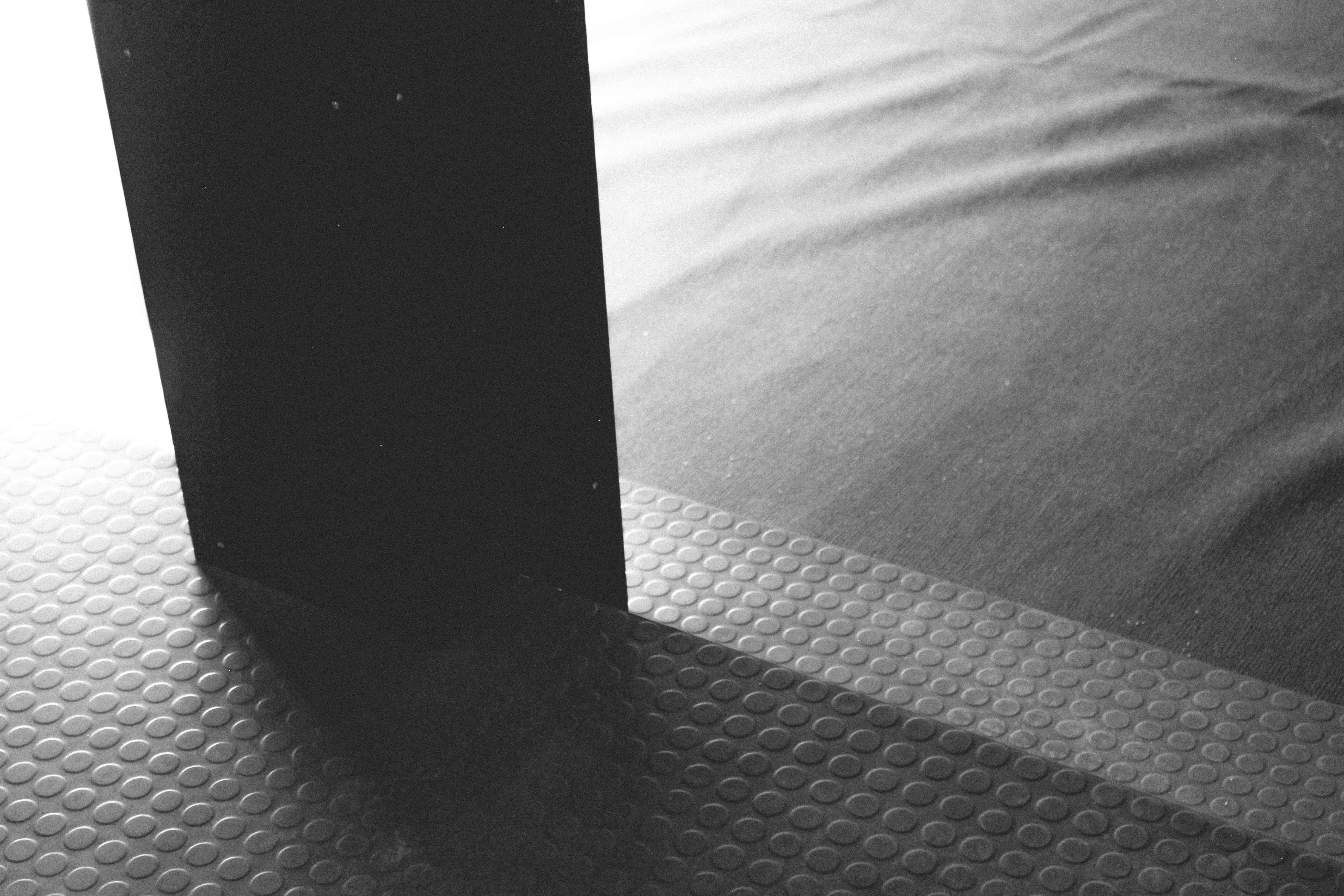 a black and white image of coin tile flooring on stairs and rippled carpet, WOE, Width Over Ears