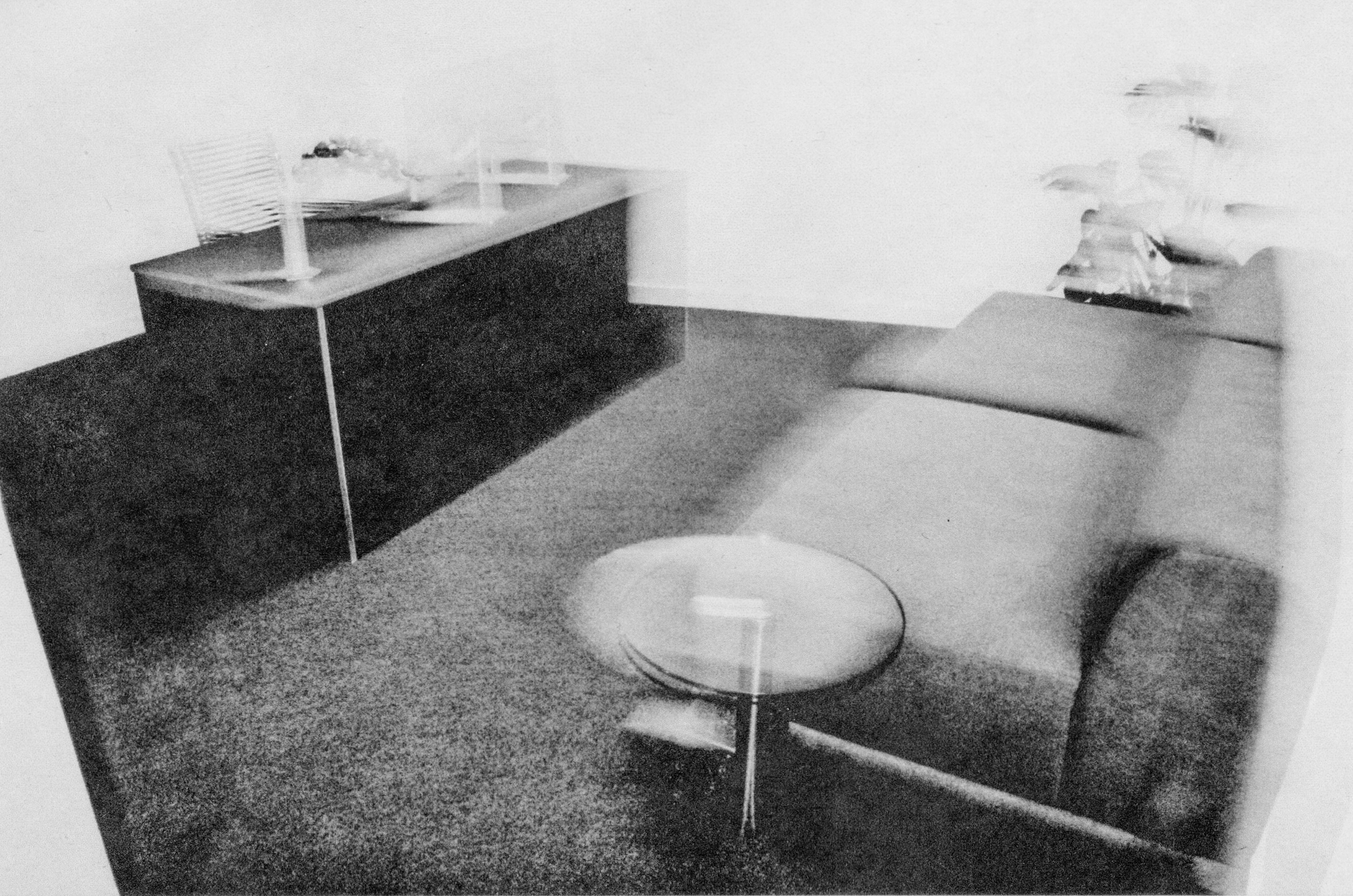 black and white image of an office with sofa and desk