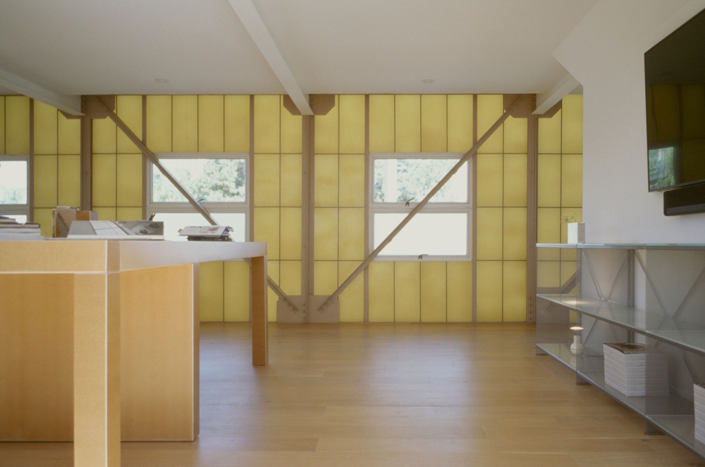 a large desk on one side of the room and large metal bookcase on the other