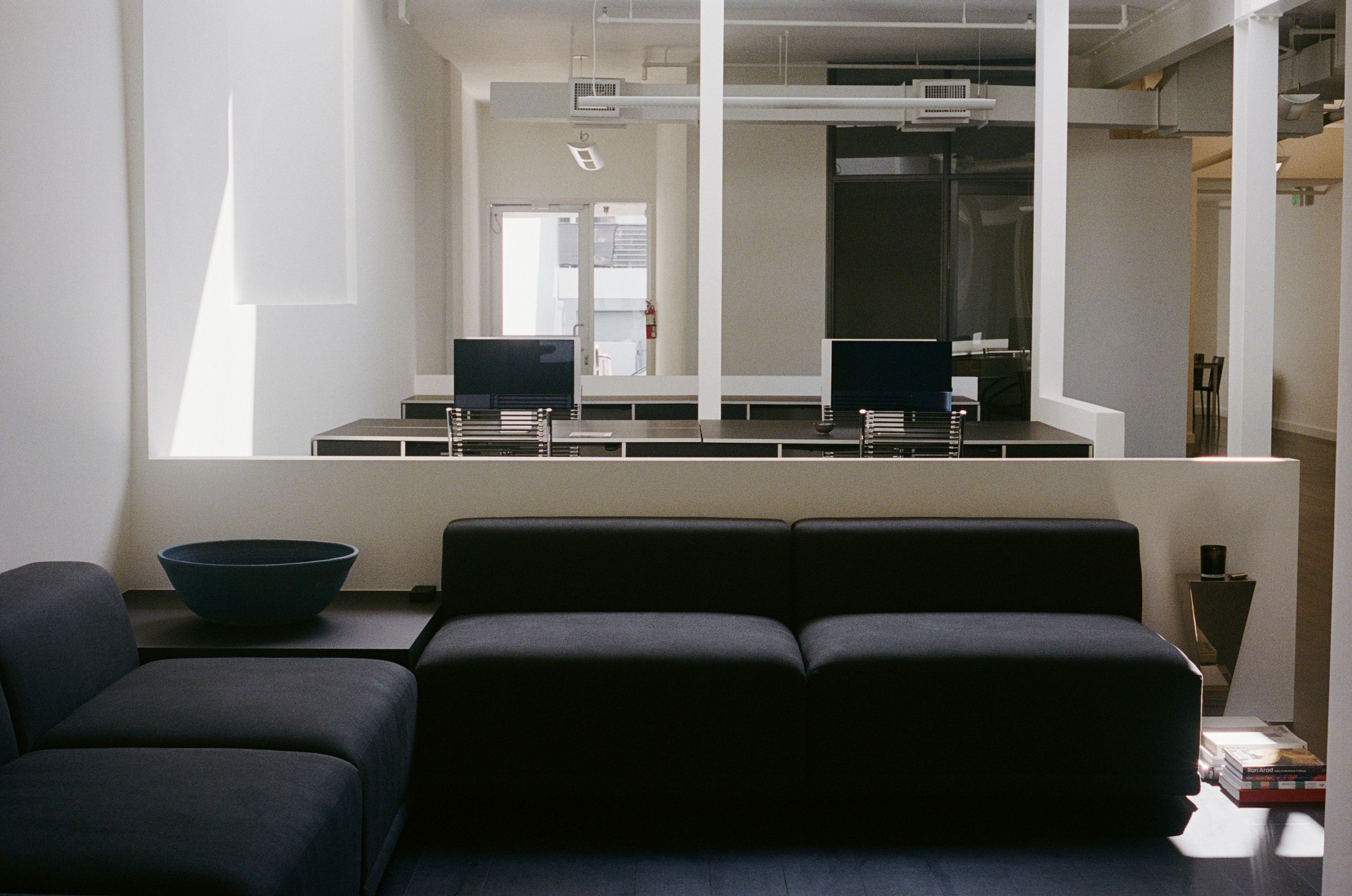 a modular sofa in front of a workroom with computers