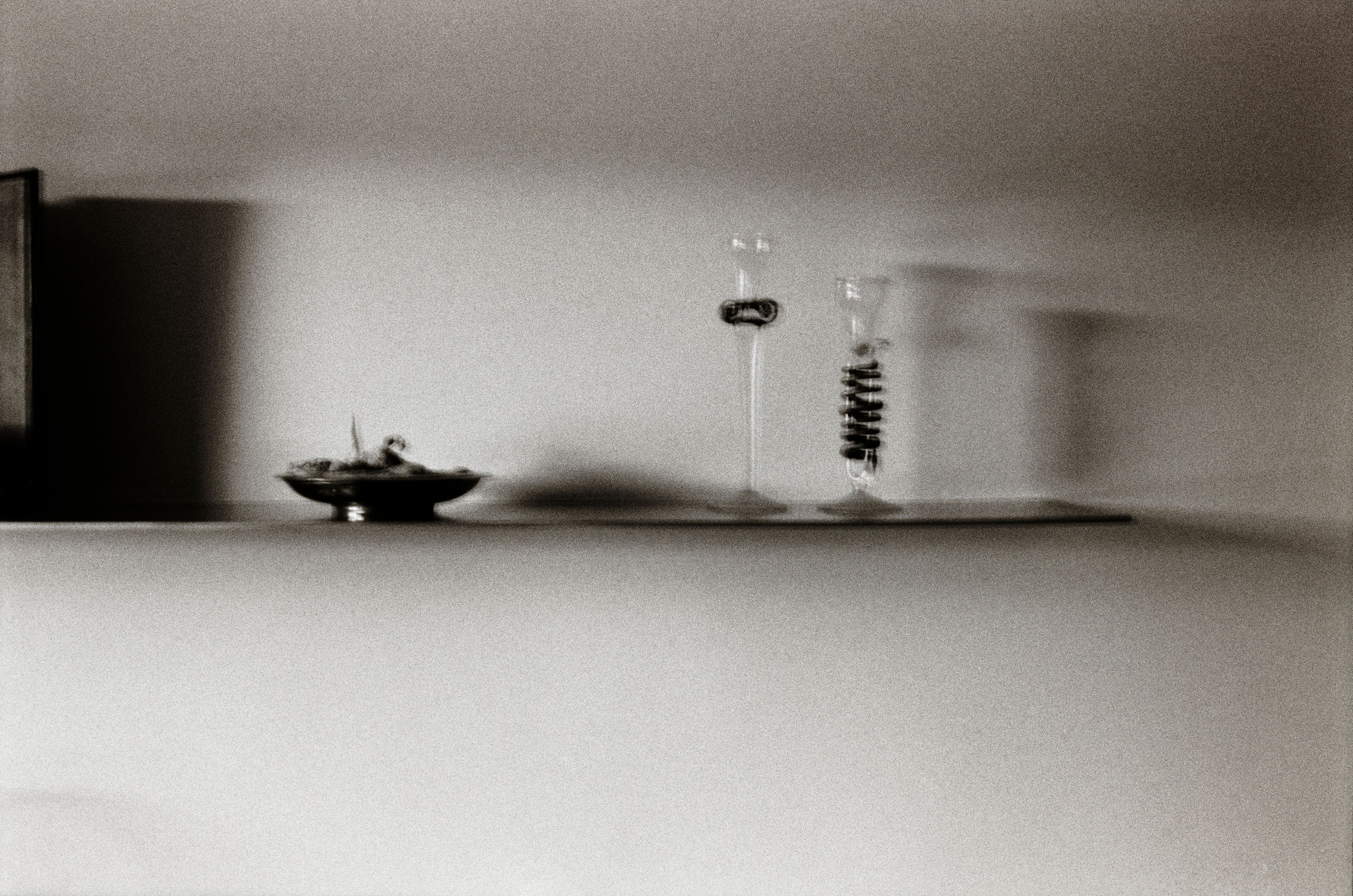 black and white image of a kitchen shelf with objects on it