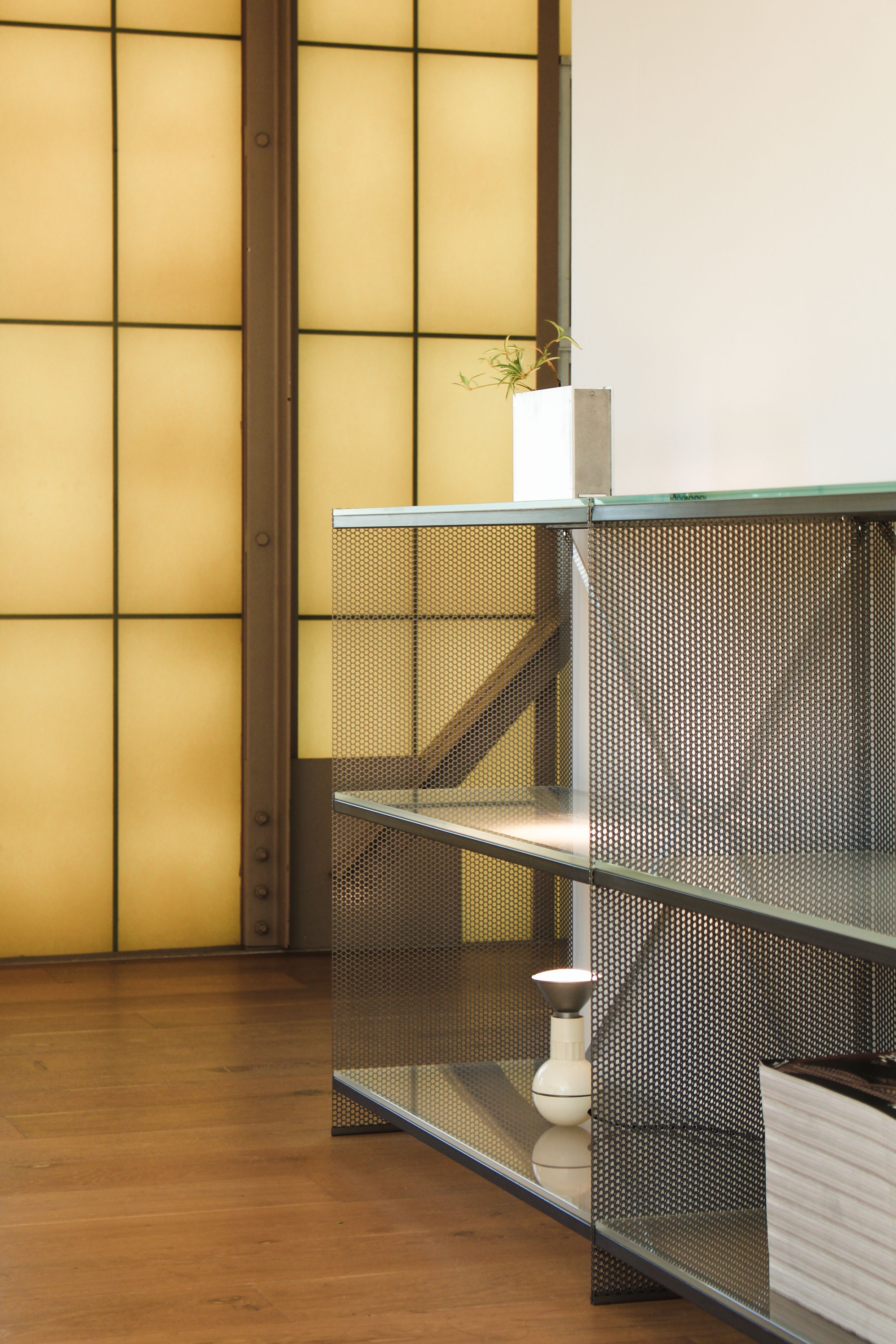 metal and glass bookshelves with fiberglass walls behind