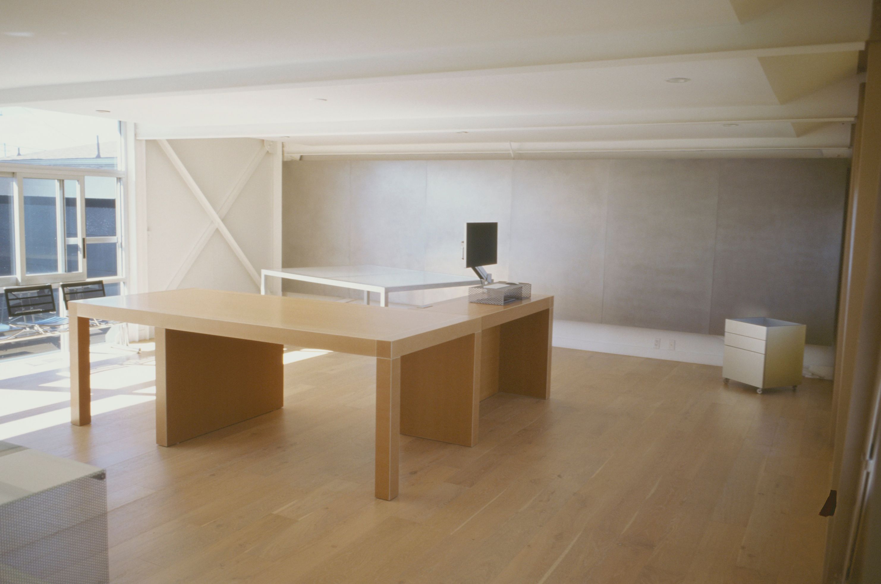 a large desk in the middle of a room with wooden floors