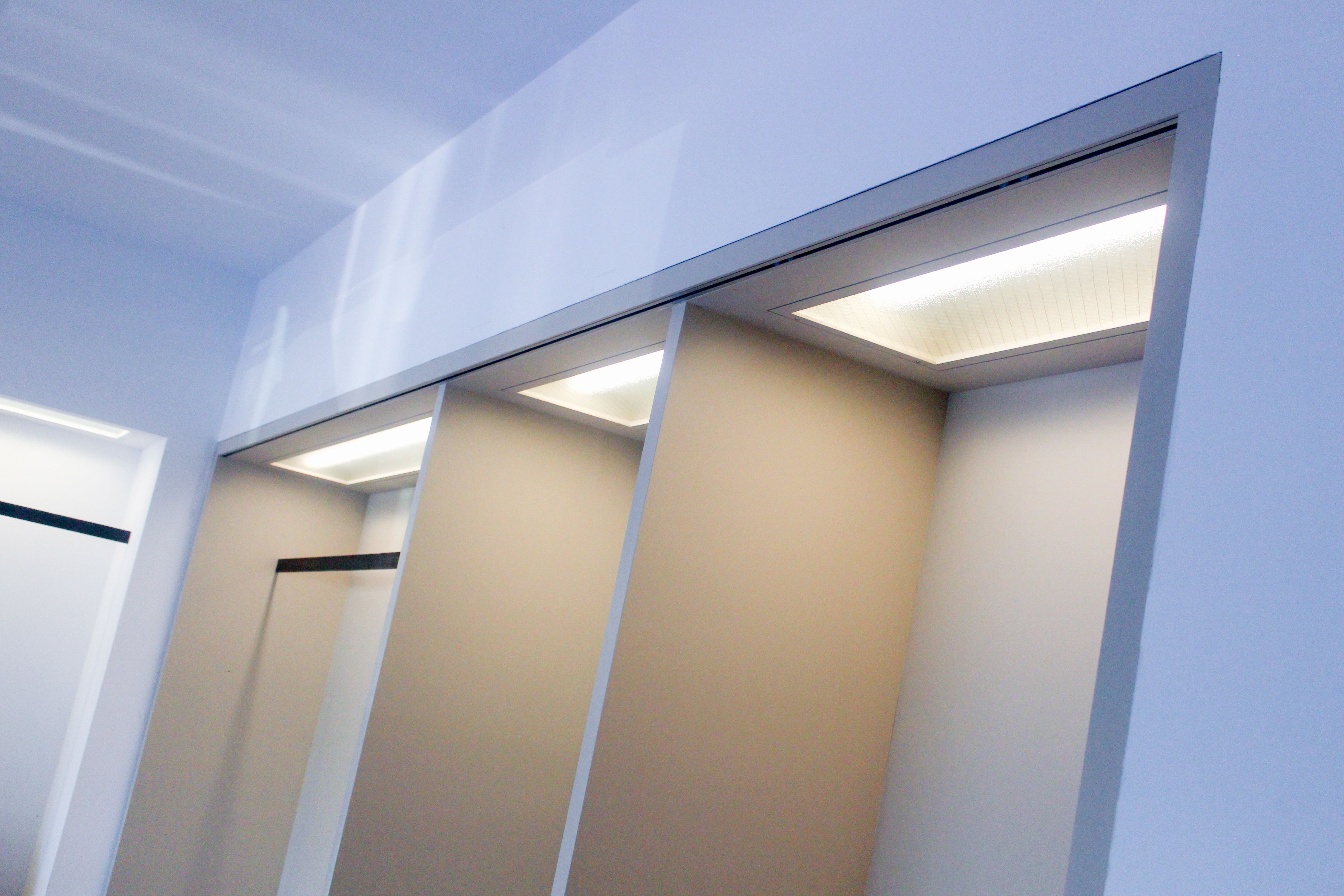 a cabinet with overhead lights shining down, WOE, Width Over Ears