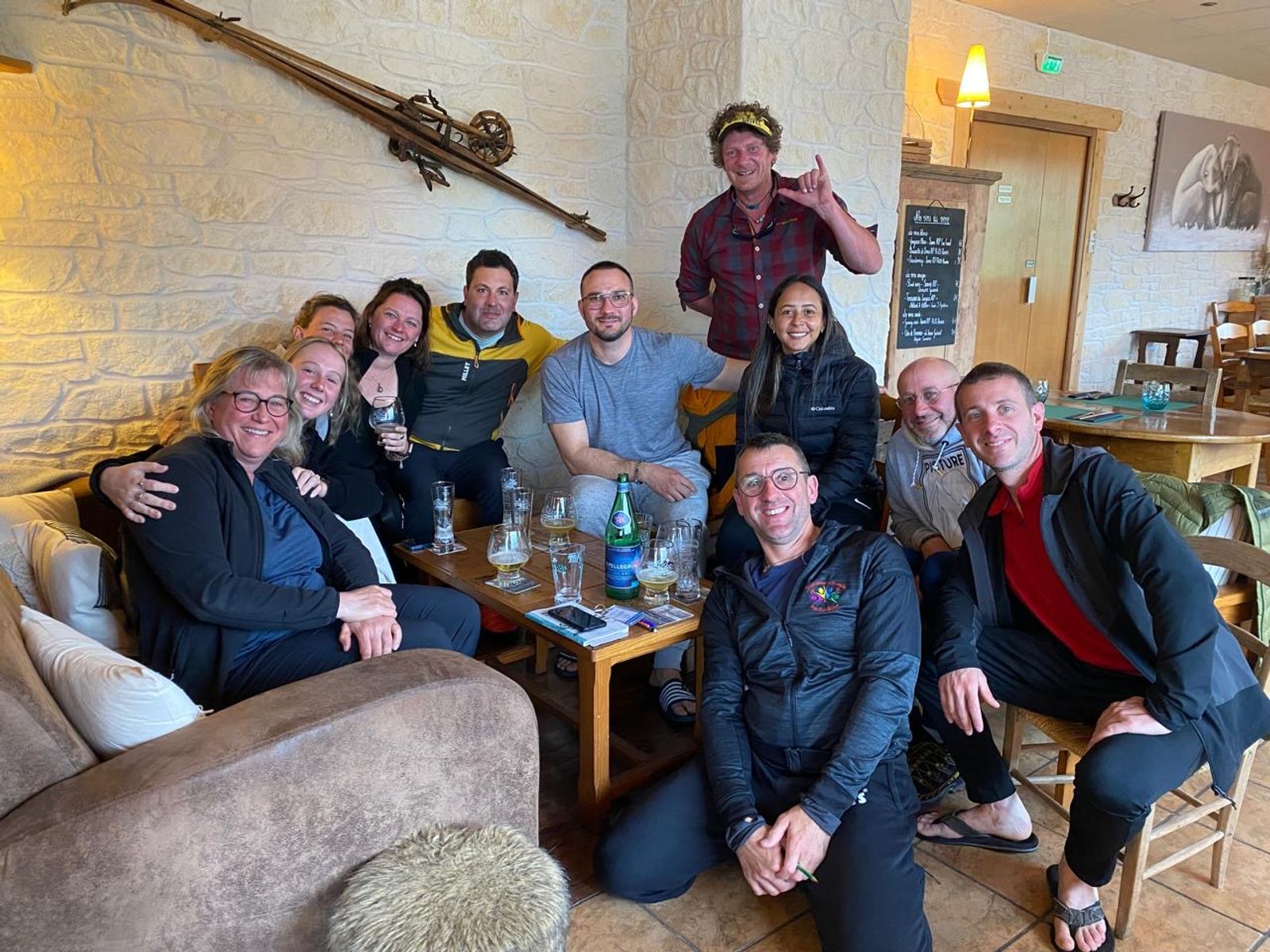 El grupo sonríe reunido alrededor de una mesa con copas en el hotel.