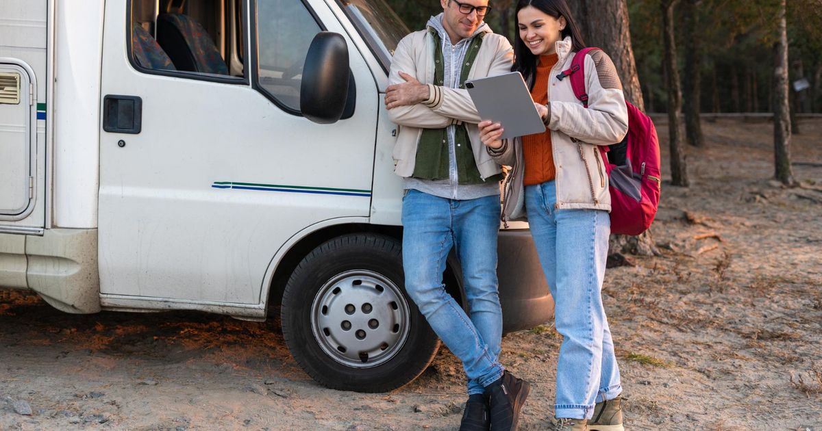 two people looking at a tablet using reservations software for an RV park