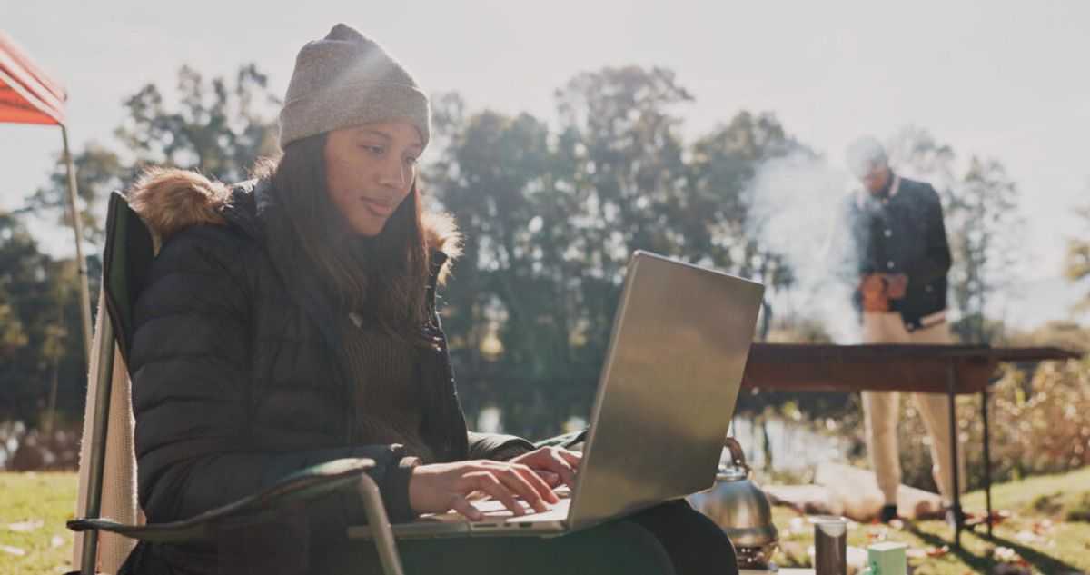 Woman using her laptop in a campground 