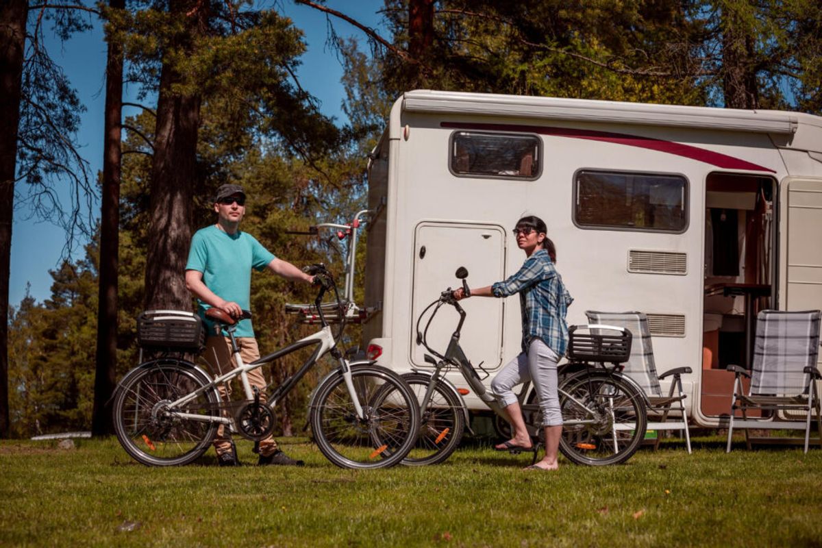 Two people with their bikes outside of their camper van in a RV park thanks to campground management systems