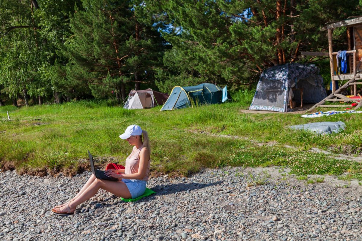 a woman using a laptop in a small RV park