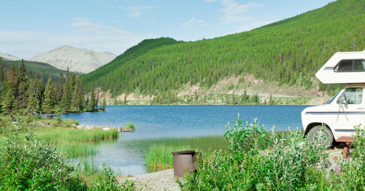 A beautiful view of a camper van in front of a lake