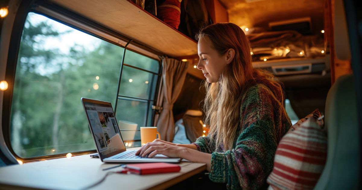 woman checking her laptop using reservation software to book a spot in an RV park