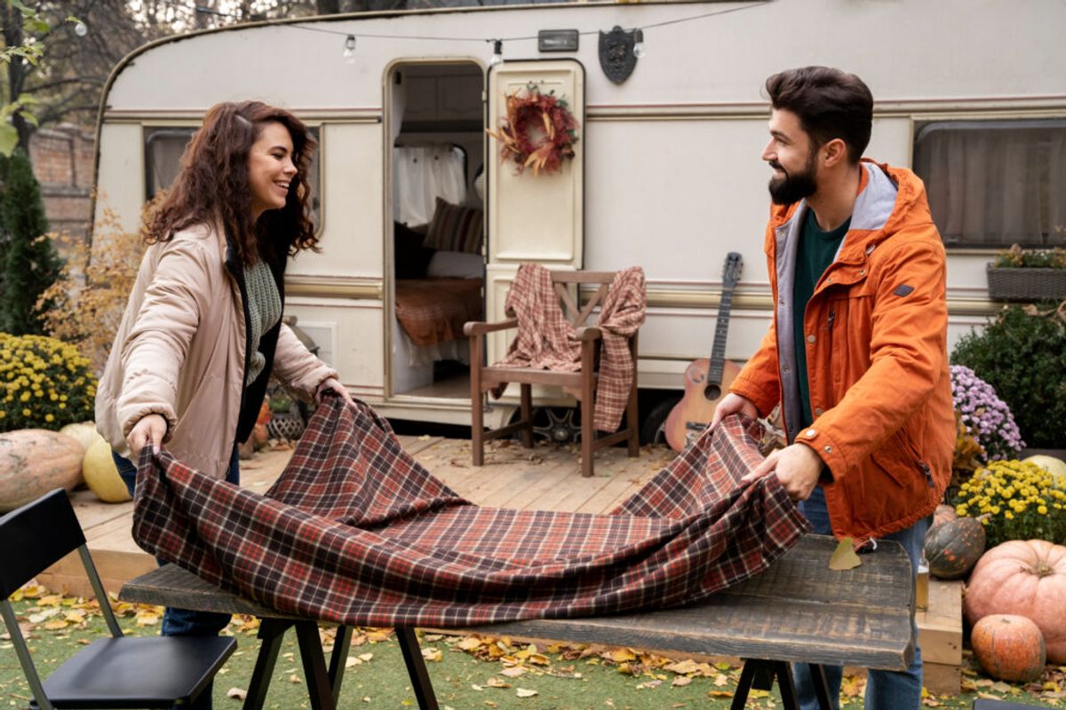 two people preparing the table outside of their camper van thanks to campground management software