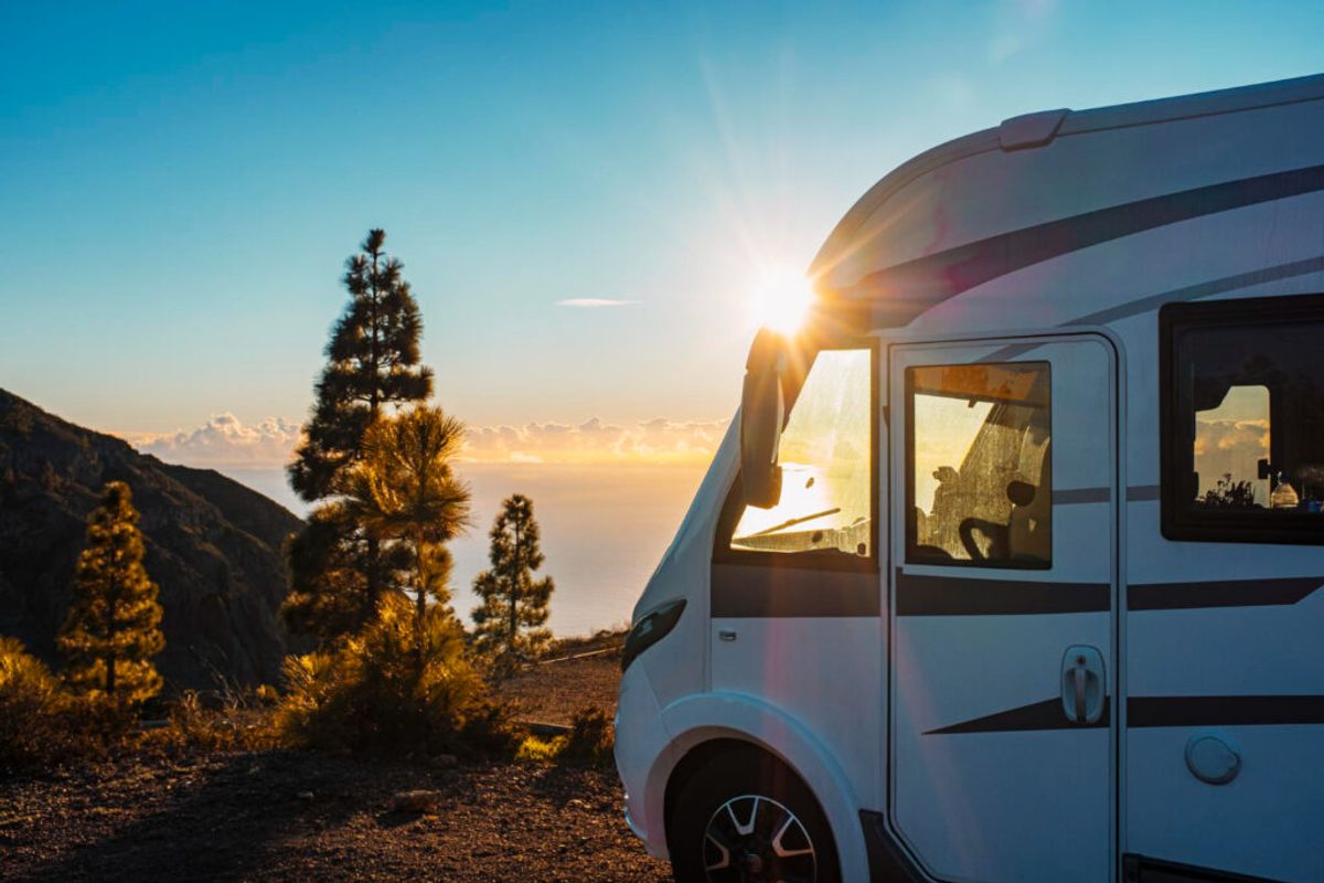 a beautiful campground in a with grey stripes in front of a sunset on a mountain