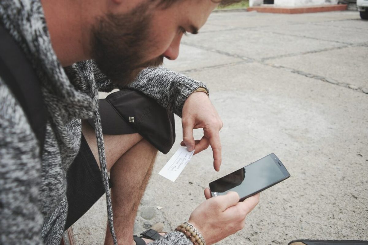 man using his phone to purchase a ticket for a festival at a campground 