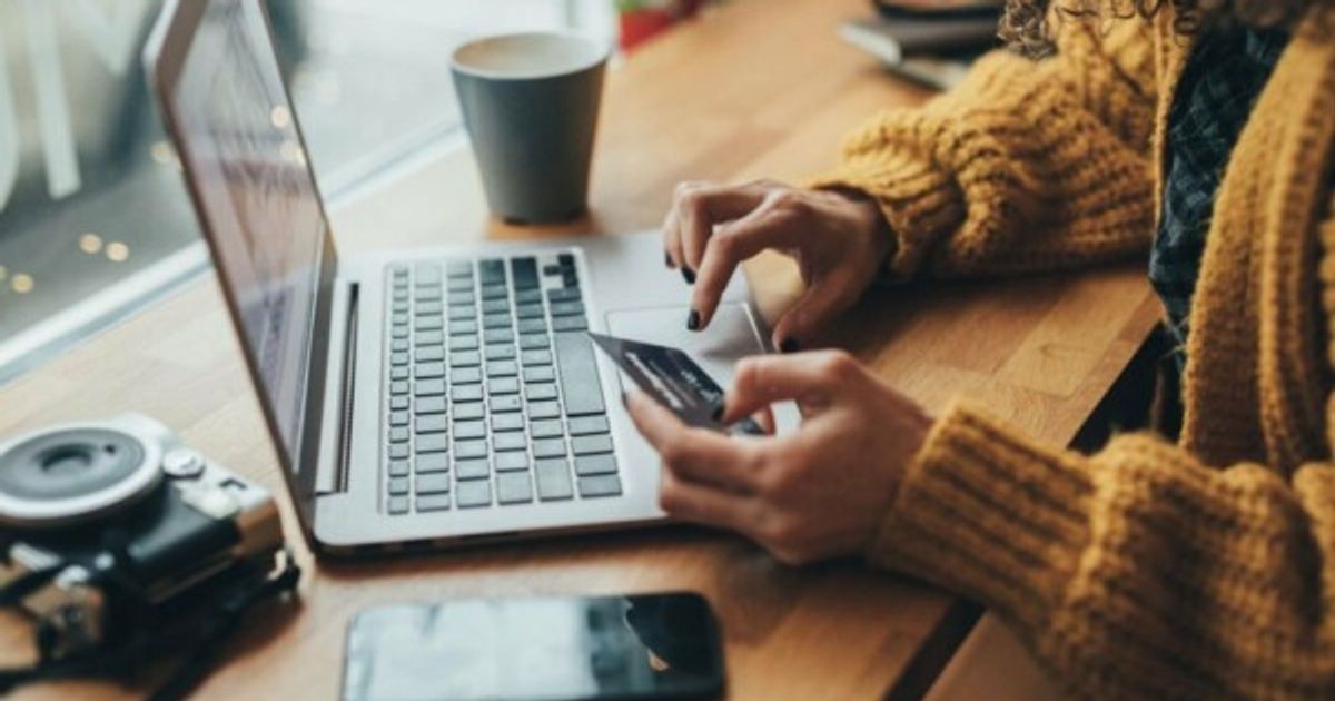 Woman in cafe shopping online with laptop