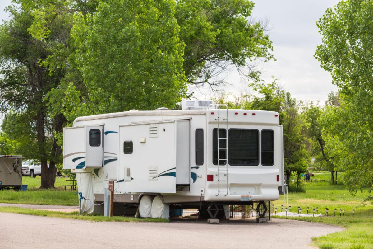 a white with blue details camper van in his campground spot 