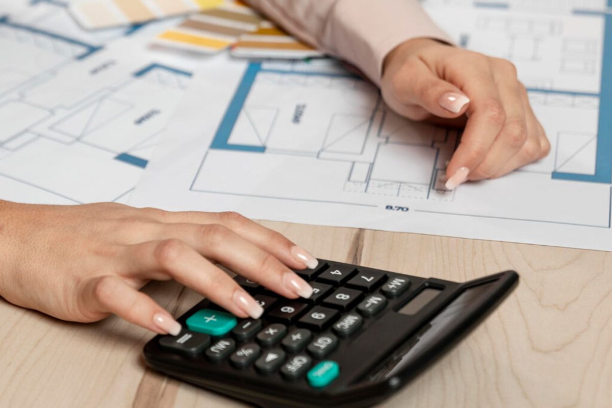 a woman using a calculator to check for the cap rate